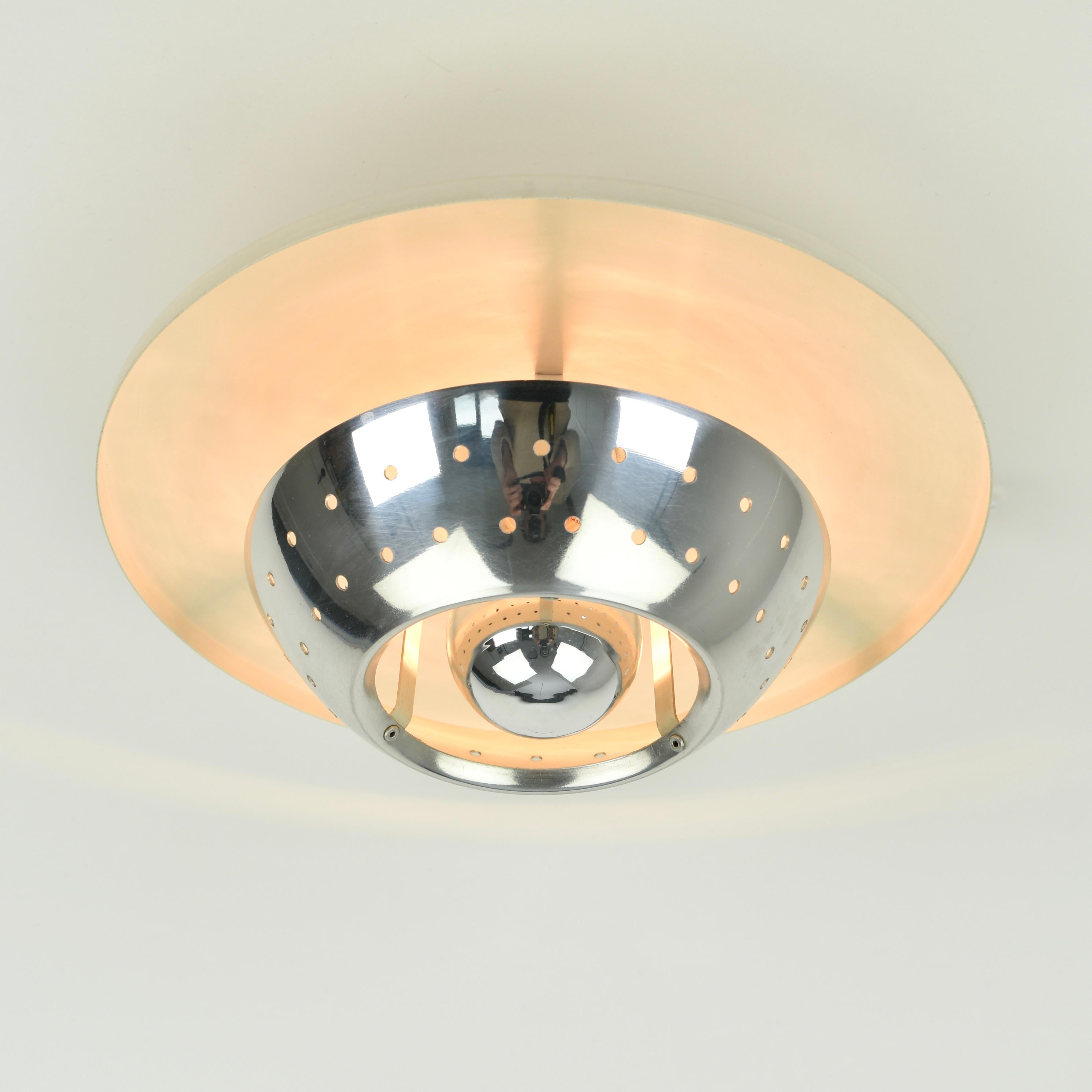 Very cool 1950s flush mount. White metal combined with a chromed perforated metal diffuser. Fitting has been replaced. Great condition, very minor traces of wear. In this picture I used a mirrored lightbulb, but any (led) E26/E27 fitting size bulb