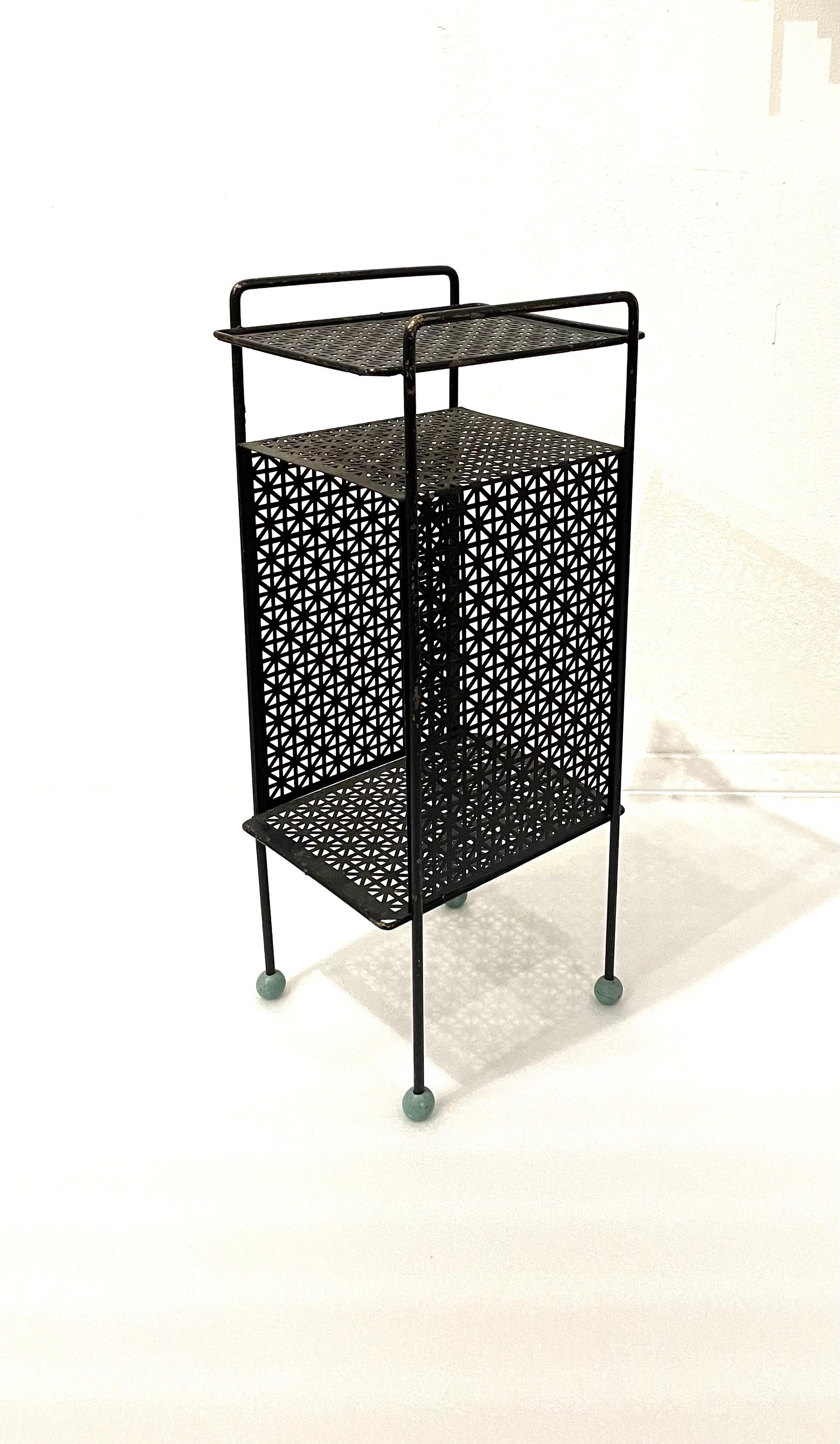 A very cool perforated metal record telephone stand rack, circa 1950's with painted wood balls feet the black enameled finish shows wear and chips to the paint due to age its sold AS/IS condition it could easily be resprayed, but we are selling it