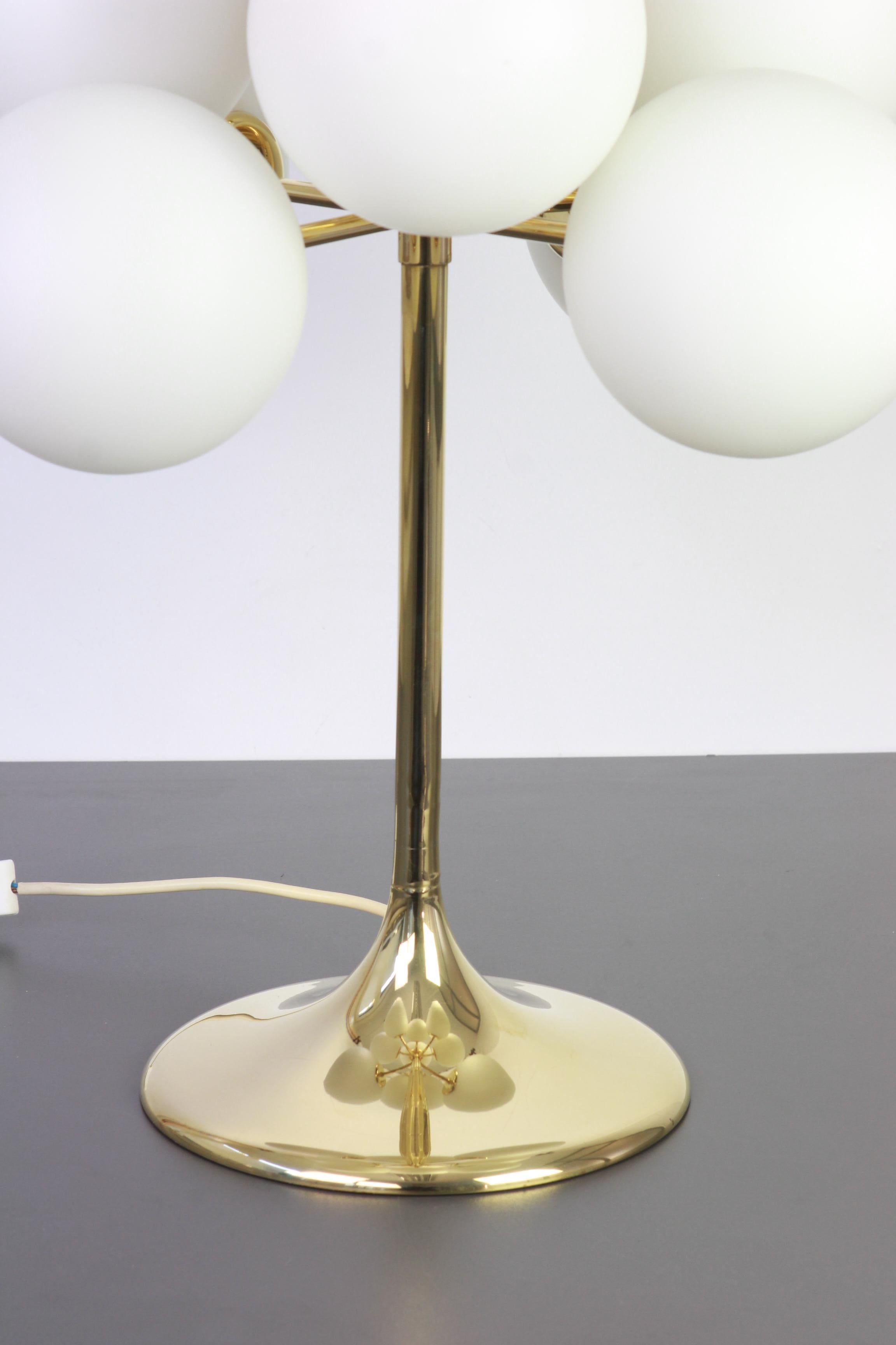 Atomic brass table lamp with nine-glass globes. The globes are hand blown and fitted with a screwing device.

High quality and in very good condition. Cleaned, well-wired and ready to use. 

The fixture requires 9 x E14 standard bulbs and is
