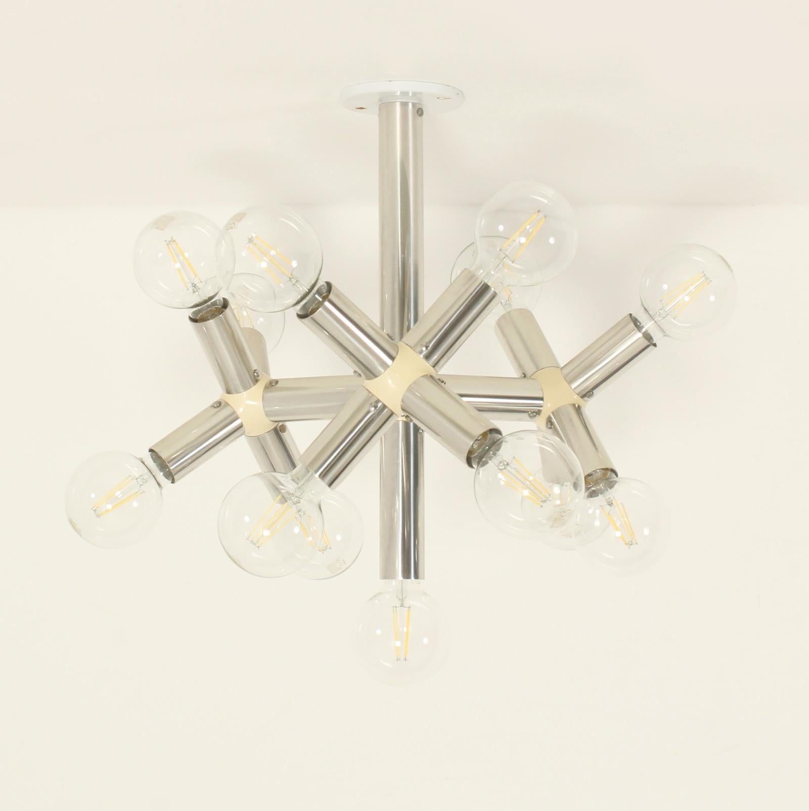 Lámpara de techo atómica diseñada en 1965 por Trix and Robert Haussmann para Swiss Lamps International, Suiza. Estructura modular compuesta por tubos de aluminio unidos por piezas de plástico con trece bombillas E27 (no incluidas).