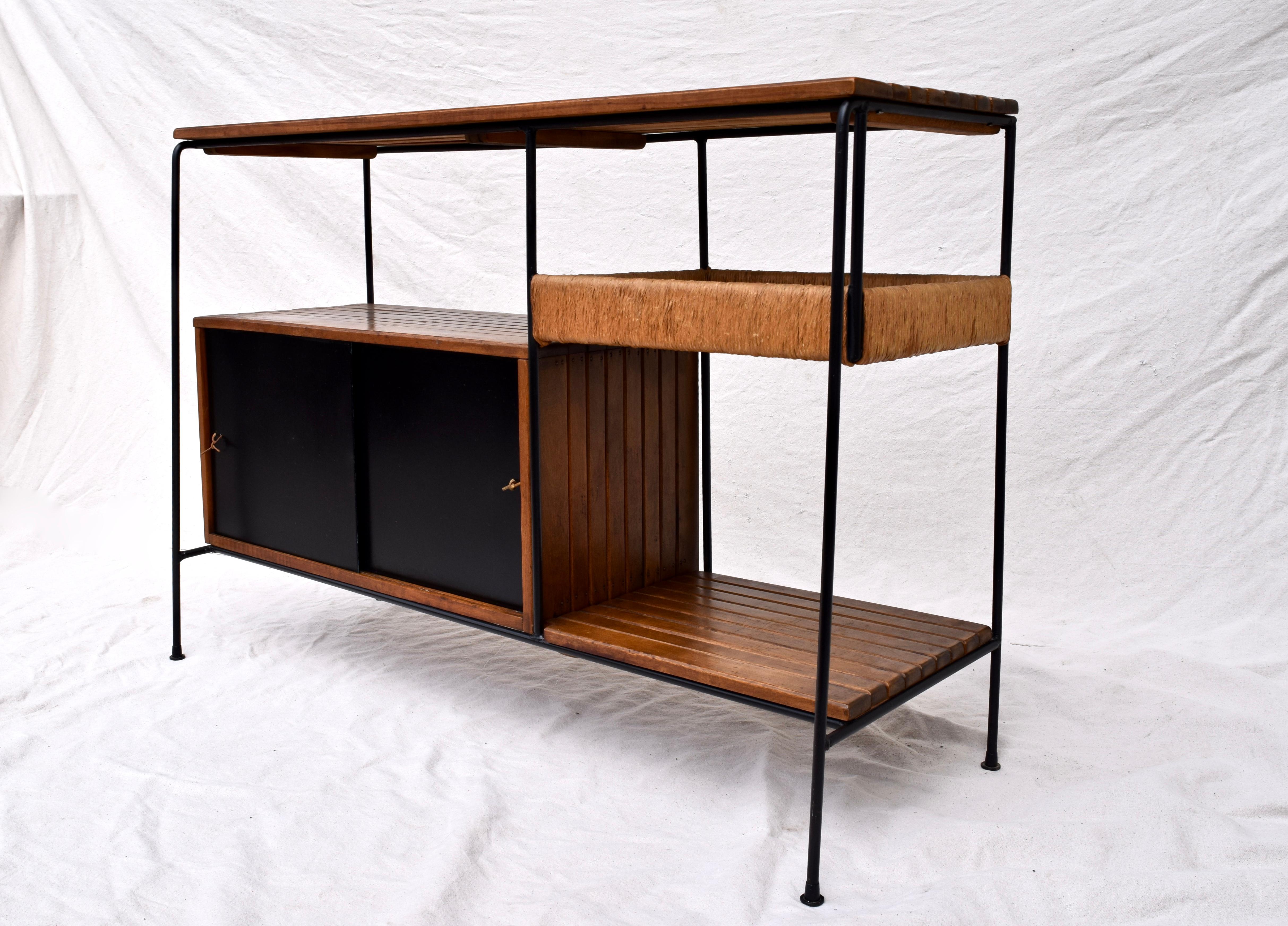 An unusual find by Arthur Umanoff useful as sideboard, server or bar among many possibilities. Features Umanoff's signature style consisting of slat wood, wrought iron, rush, masonite doors and back with leather pulls. We have fully detailed this
