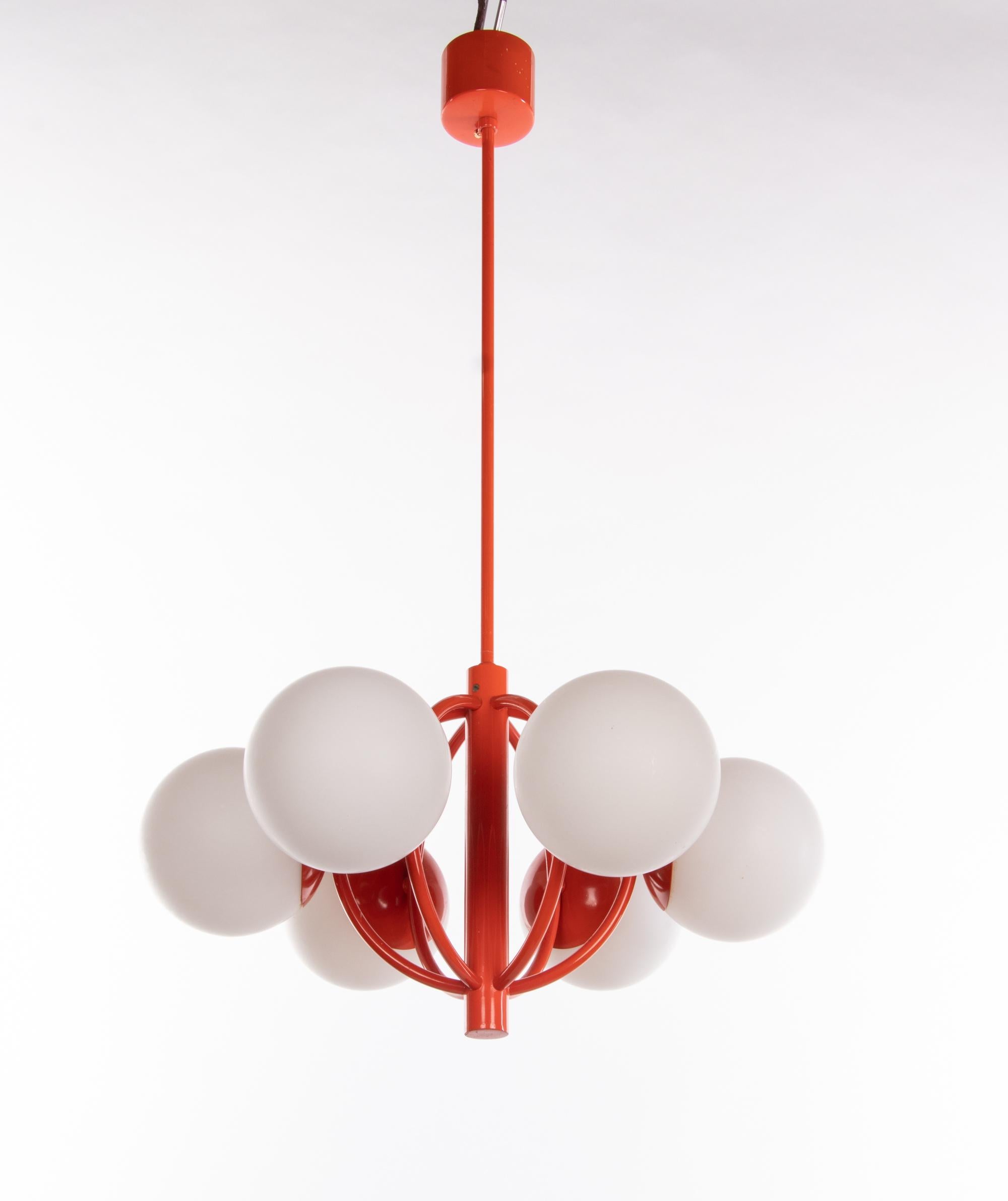 Elegant molecular atomic chandelier with six white opal glass balls on an orange-red metal frame. Manufactured by Kaiser Lighting, Germany in the 1960s. 

Measures: diameter 17.7