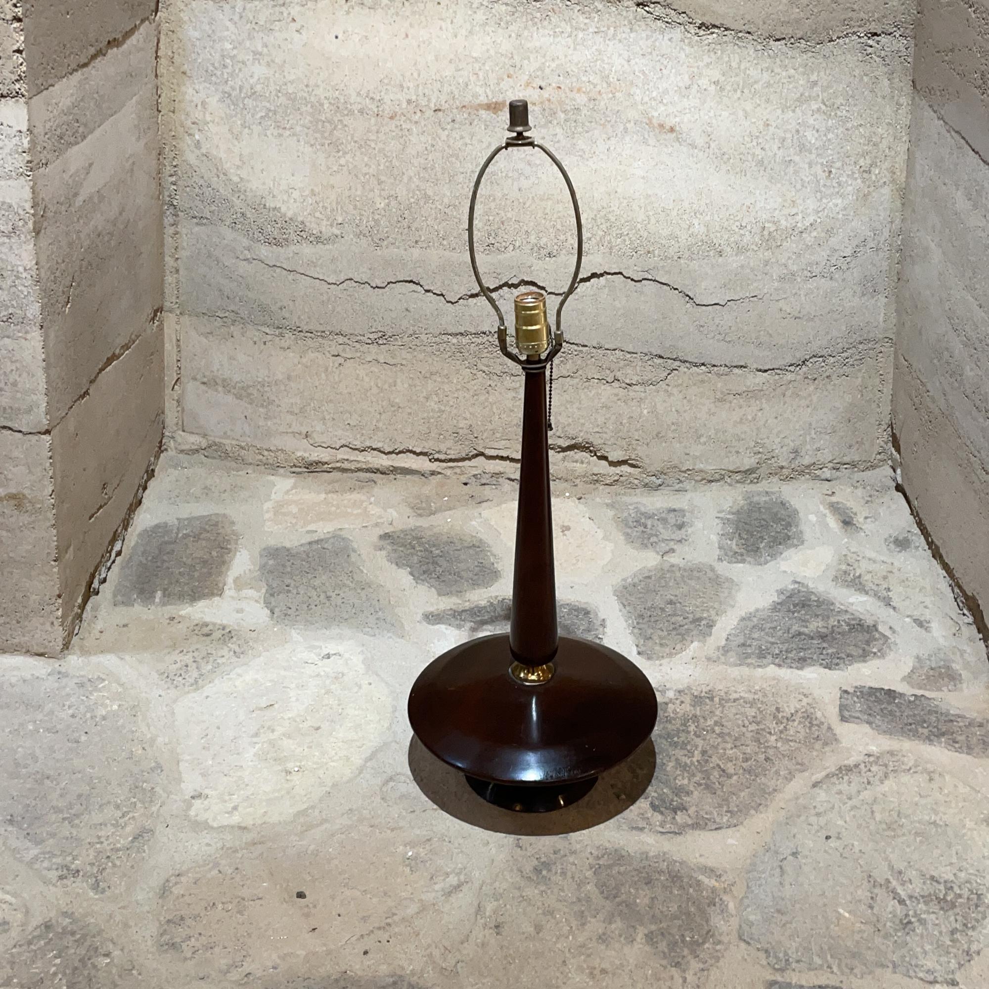 Mid-Century Modern atomic table lamp designed with a tapered tower in mahogany wood on a round saucer base, Mexico, circa 1950s
Measures: 24 tall (base of socket) x 12 diameter inches
Original unrestored preowned vintage condition. See our