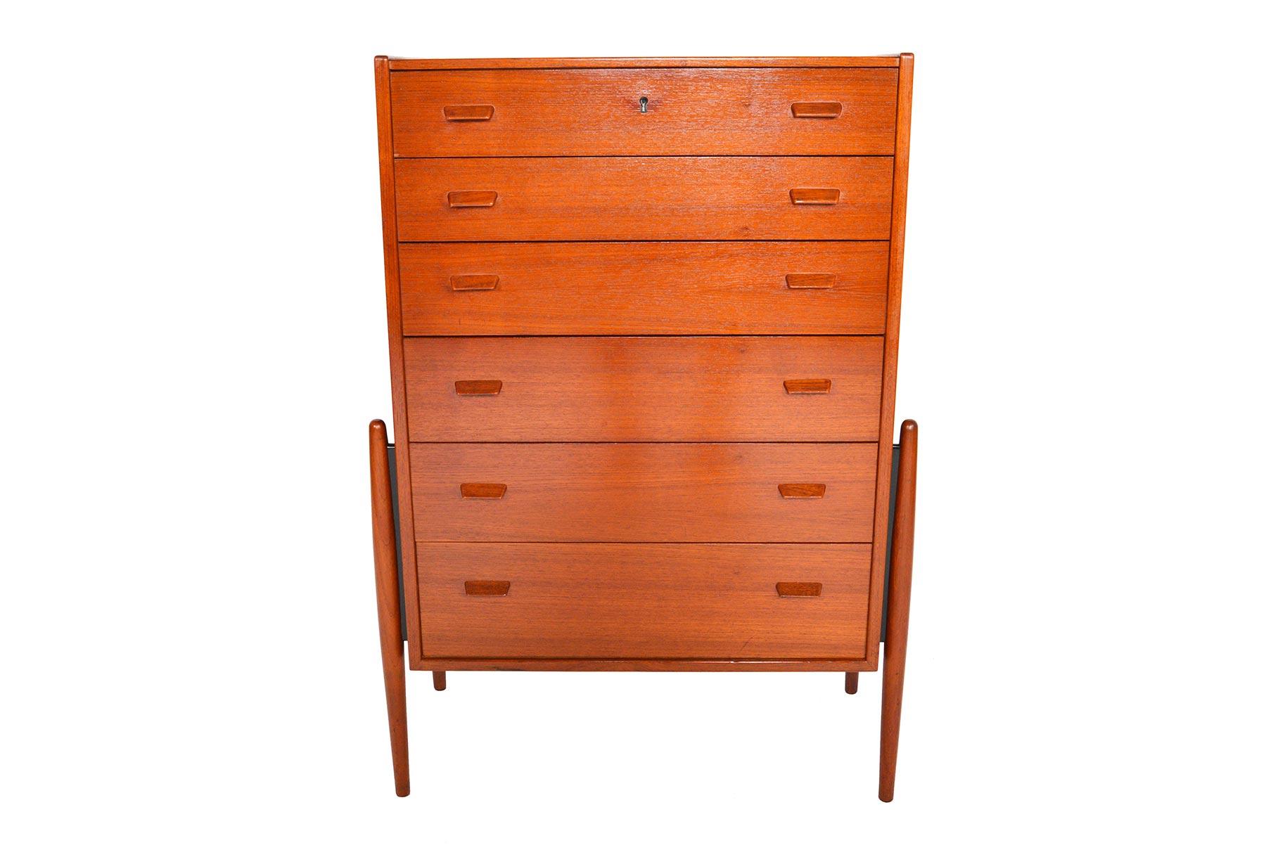 This exceptionally rare Danish modern midcentury teak highboy dresser will make a statement in any modern home. Built like a rocket, this atomic design features four exterior mounted teak spindle legs. Drawers become progressively deeper towards the