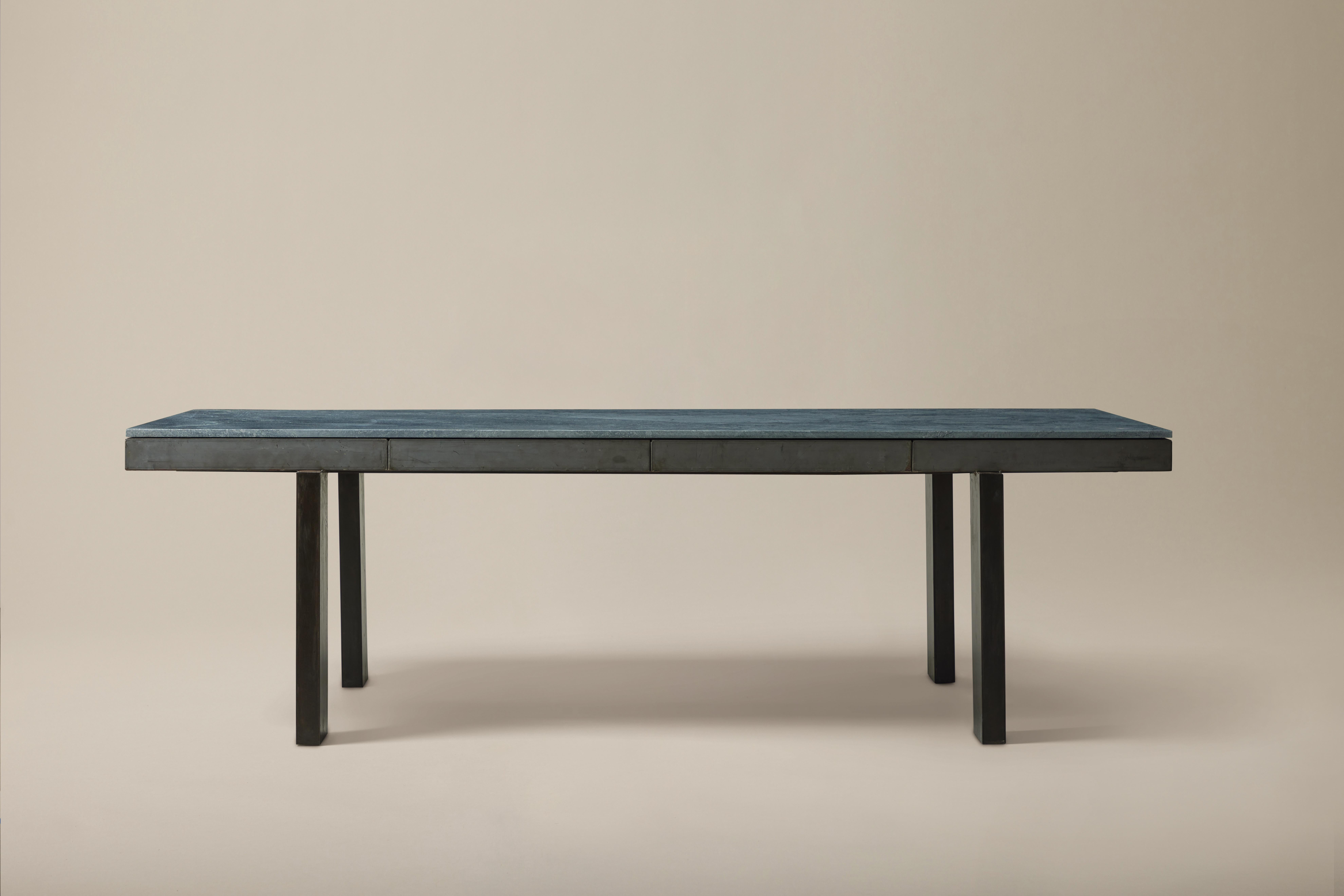 This statement 1940s dining table boasts a gray-green soapstone atop a steel frame with outset rectangular legs. Note: A shim is recommended for leveling. Slight gapping in the soapstone is visible in one corner. Patina on the steel frame,