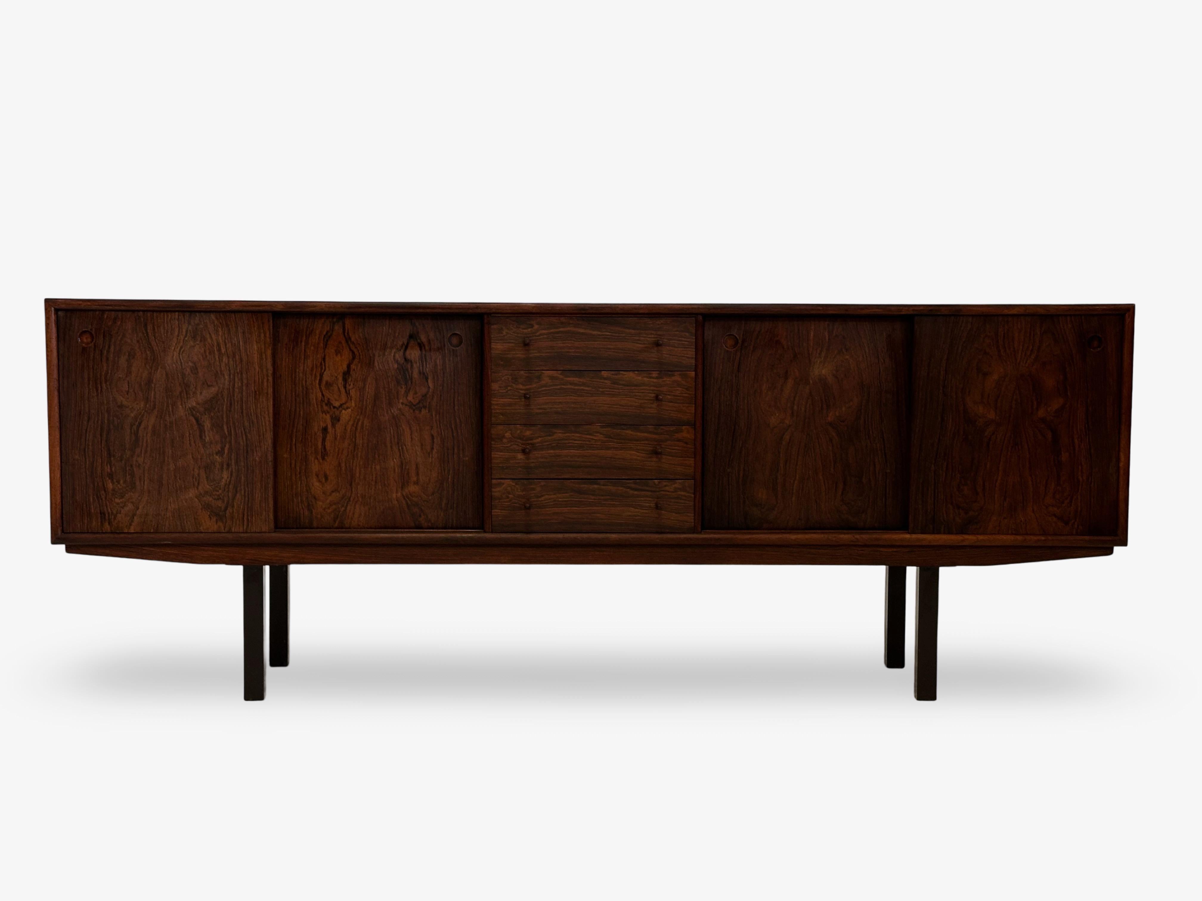 Low rosewood sideboard with original metal legs.
Original colored sliding doors and drawers in rosewood.
All the doors can be reversed to give the sideboard the desired expression.
This is a very early and rare piece.