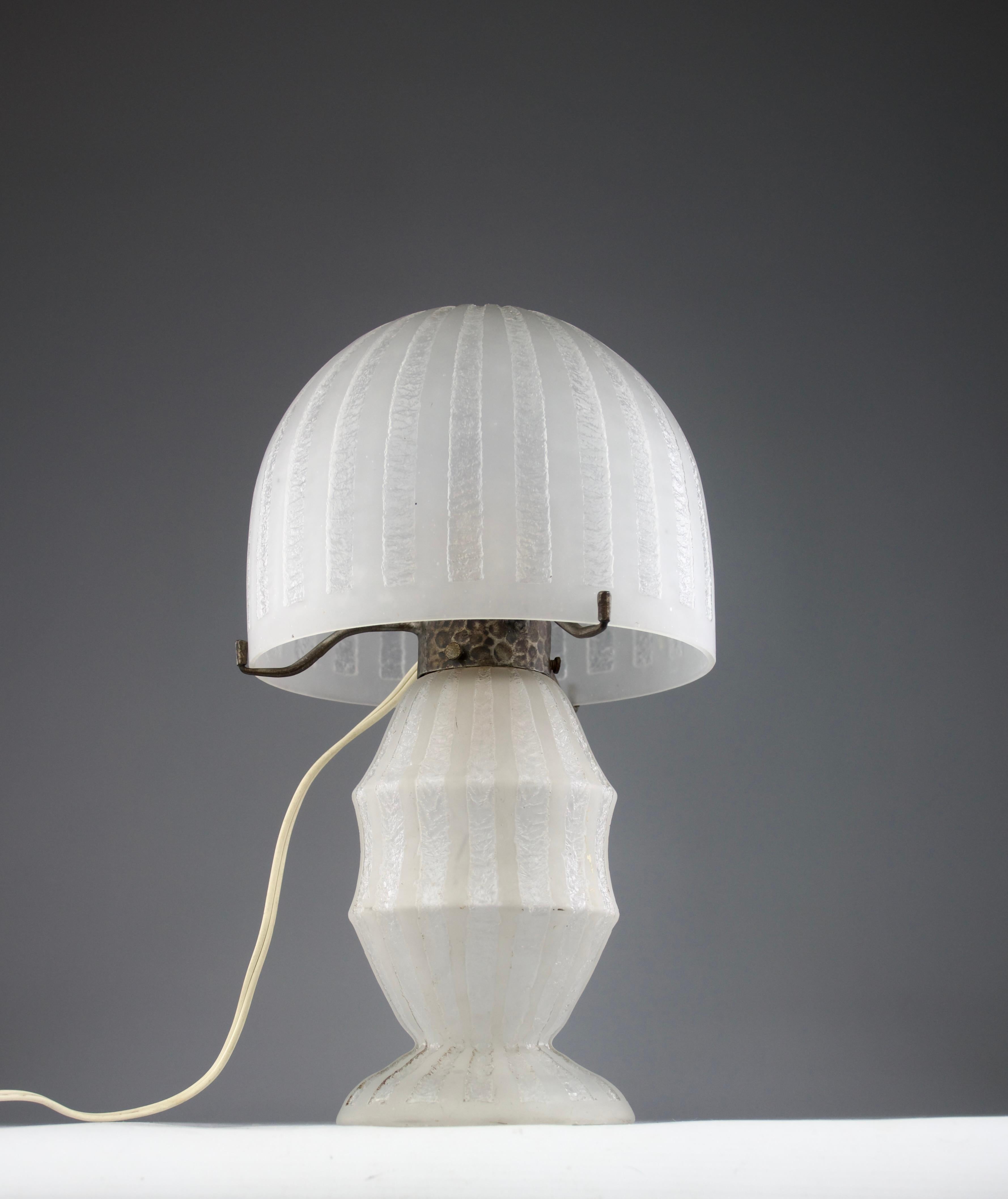 Bellissima lampada da tavolo in vetro bianco acidato del periodo Art Déco degli anni '20, attribuita alla manifattura Daum. Supporto per paralume in ferro martellato.

In ottime condizioni.

Dimensioni in cm ( H. x D. ) : 30 x 16

Spedizione sicura.