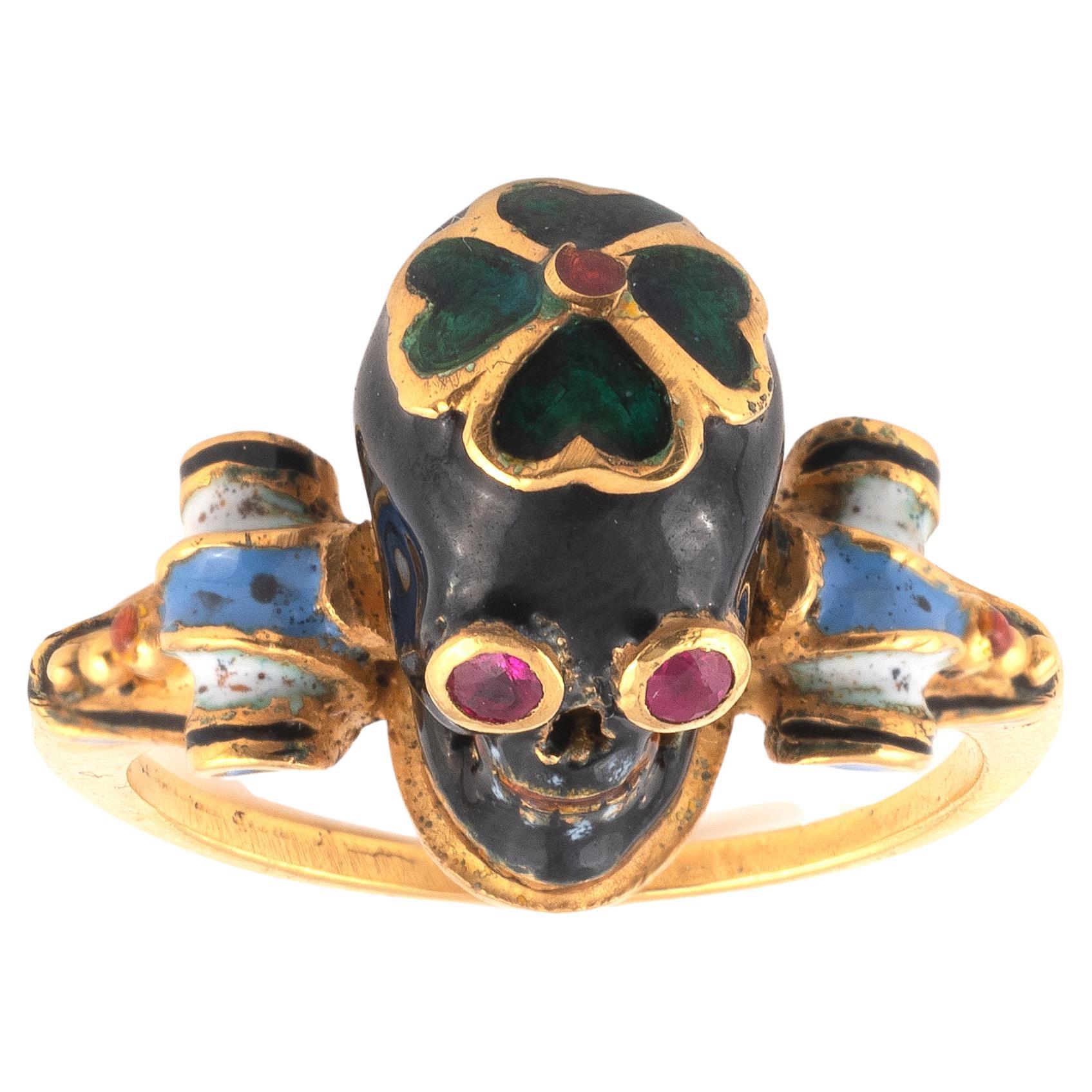 The ruby eye black enamel Memento Mori skull surmounted by a dark green enamel quatrefoil, the shoulders decorated with multi colored enamel scrolls. Mounted in 18Kt yellow gold Signed A. Codognato Venezia

Finger size: 7
Weight: 7,59gr