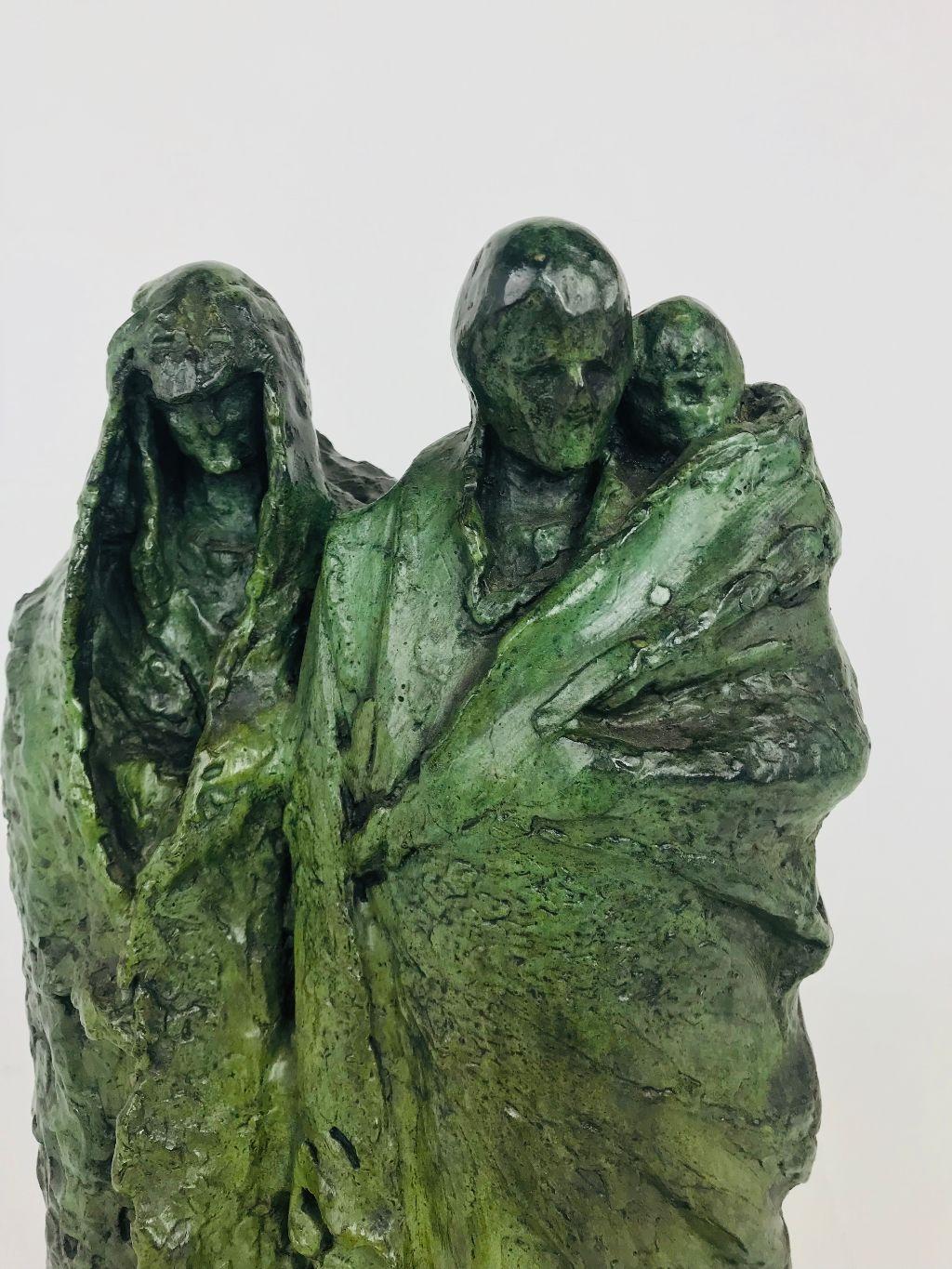 Strong midcentury bronze by noted American sculptor Attilio Piccirilli depicting a huddled family consisting of a father holding a child with the mother at his side all draped in flowing robes. Dramatic folds in the fabric add to the atmosphere this