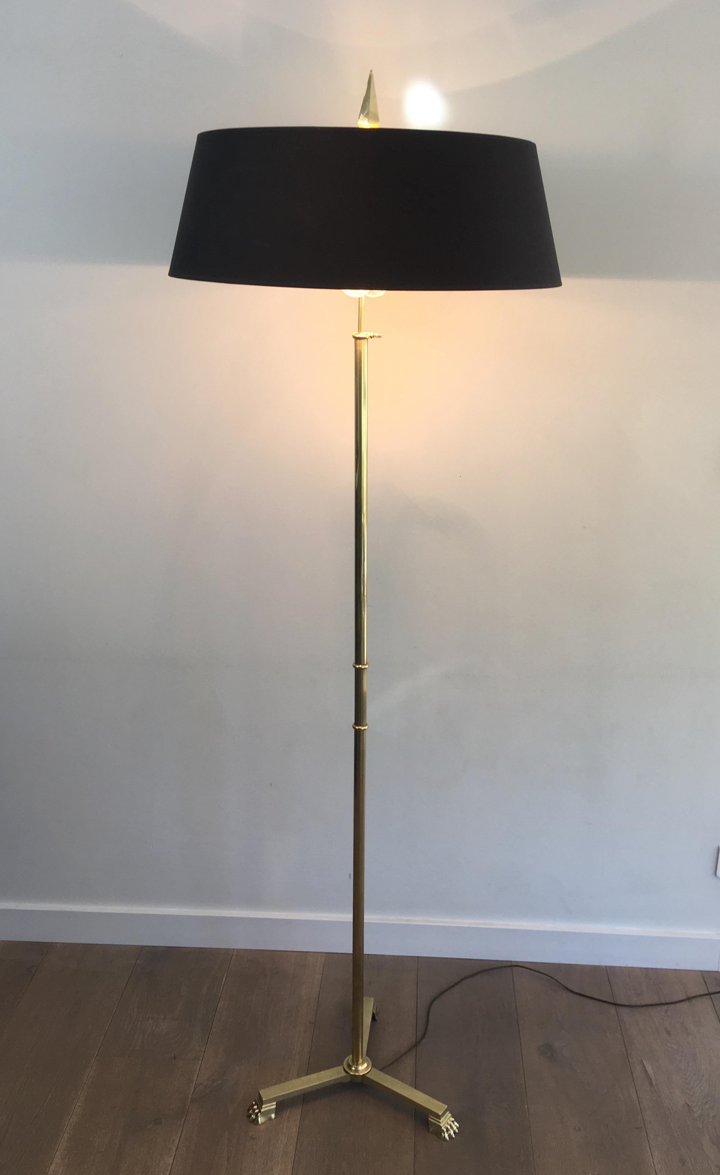 This neoclassical style floor lamp is all made of brass. This lamp has claw feet on its tripode base and a long simple finial on top. This is a very nice work attributed to famous French designer Guy Lefèvre for Maison Jansen, circa 1940.
 