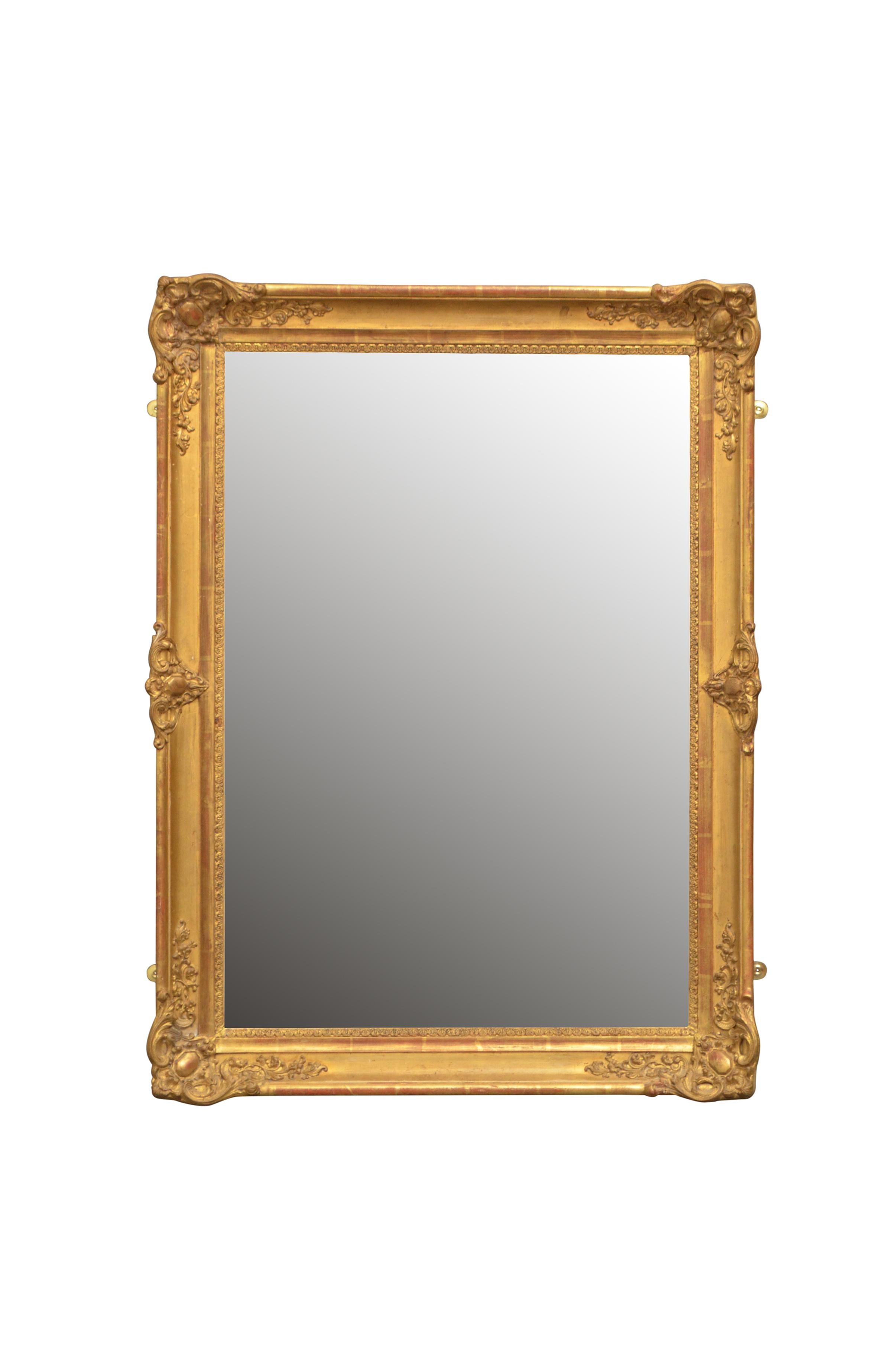 K0435 antique 19th century wall mirror of versatile form could be positioned portrait or landscape, having original mirror plate with some foxing in beautifully carved and gilded frame. This antique gilt mirror retains its original glass and gilt,