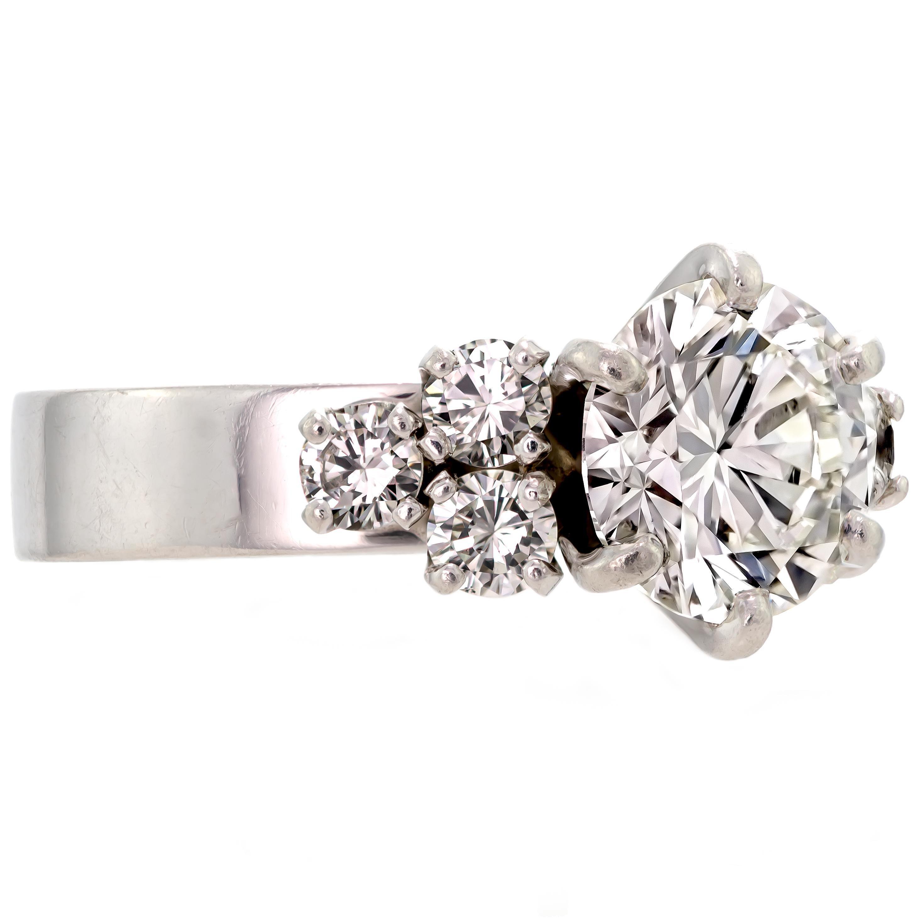 This sensational and glistening engagement ring spotlights one prong set radiant round brilliant cut diamond, flanked by three luminous round brilliant cut diamonds. All set into a timeless high polished platinum mount.  Who wouldn't love this