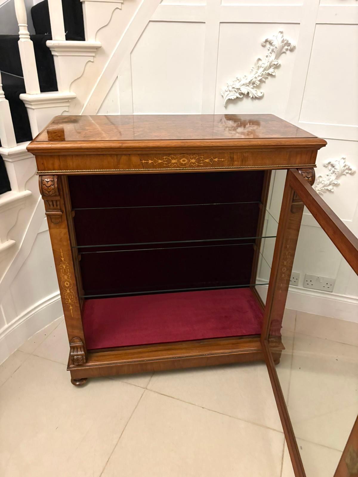 Une belle vitrine victorienne ancienne en acajou qui se distingue par ses fines incrustations et ses proportions élégantes.

Le plateau bien dessiné à bord mouluré est traversé par un bandeau et terminé par un cordage en bois satiné qui fait écho à