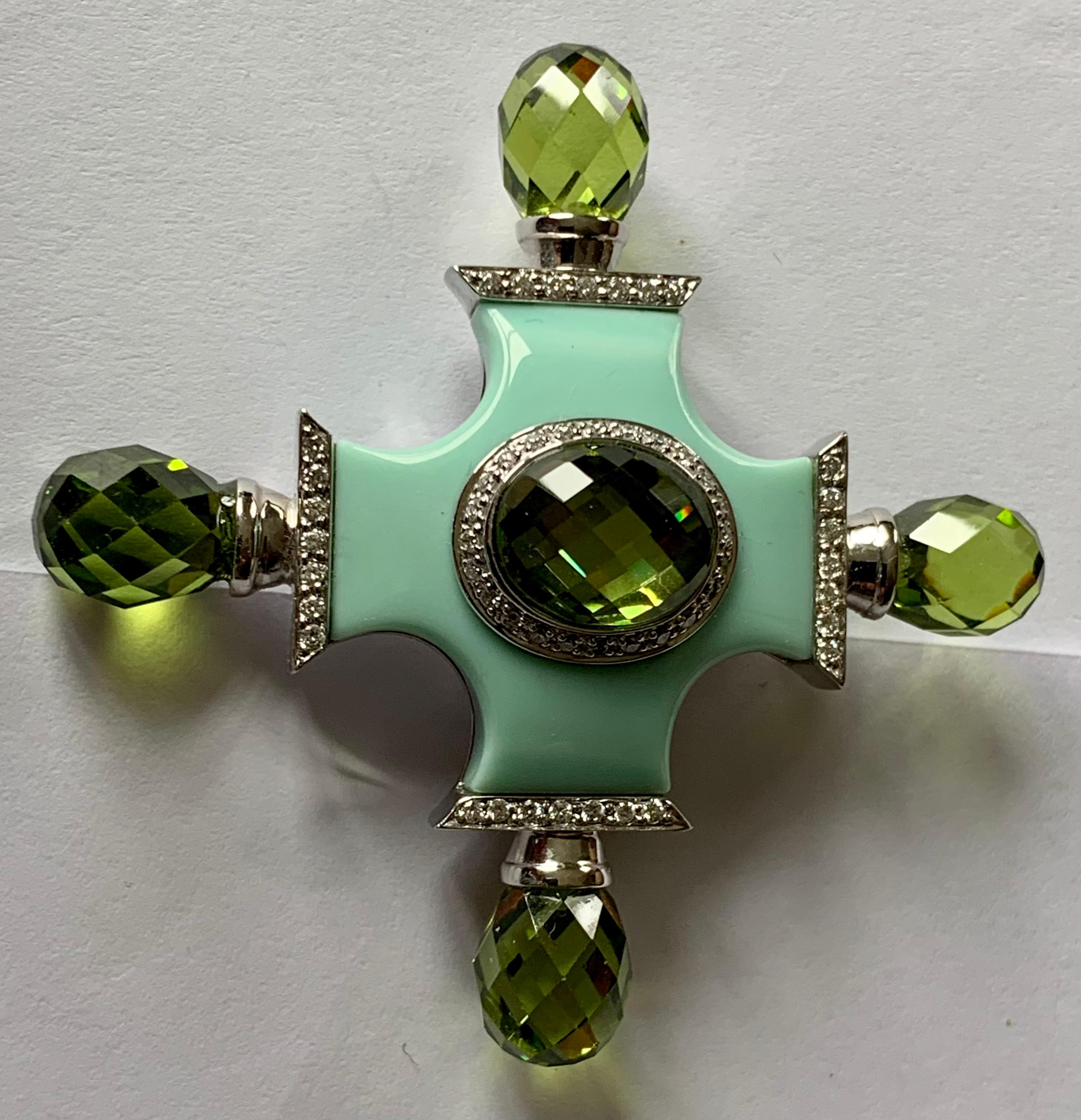 An 18 Karat white Gold and Diamond Maltese Cross Pendant/Brooch. The main part of the brooch/pendant is a light turquoise colored ceramic body. The piece is set with Diamonds weighing 0.42 ct and green Quartz in Briolette cut.
A truly beautiful