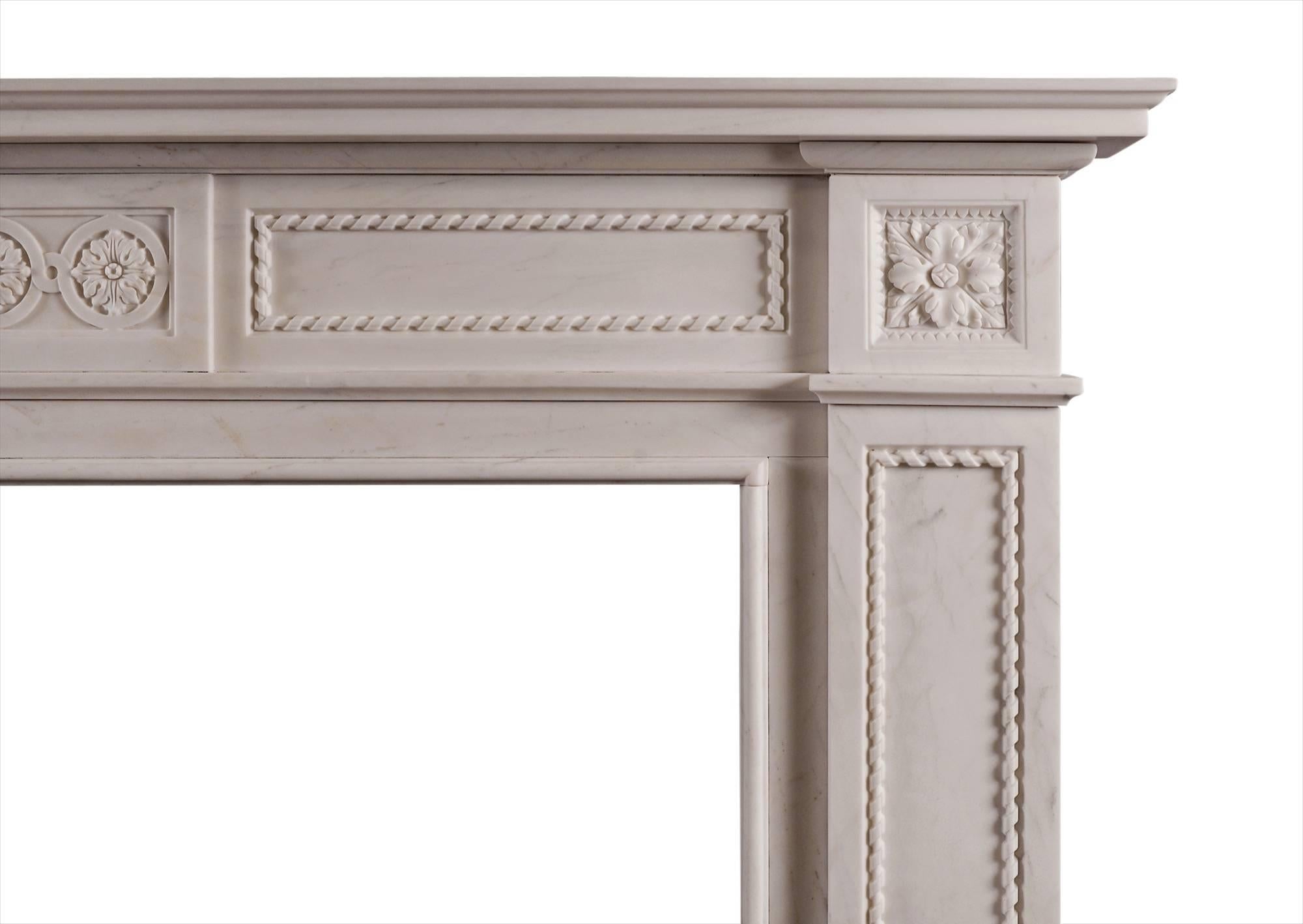 An attractive English fireplace in white marble. The frieze with centre panel featuring carved guilloche pattern and carved rope moulding to side panels. The jambs with matching rope moulding surmounted by carved square paterae. A copy of a late