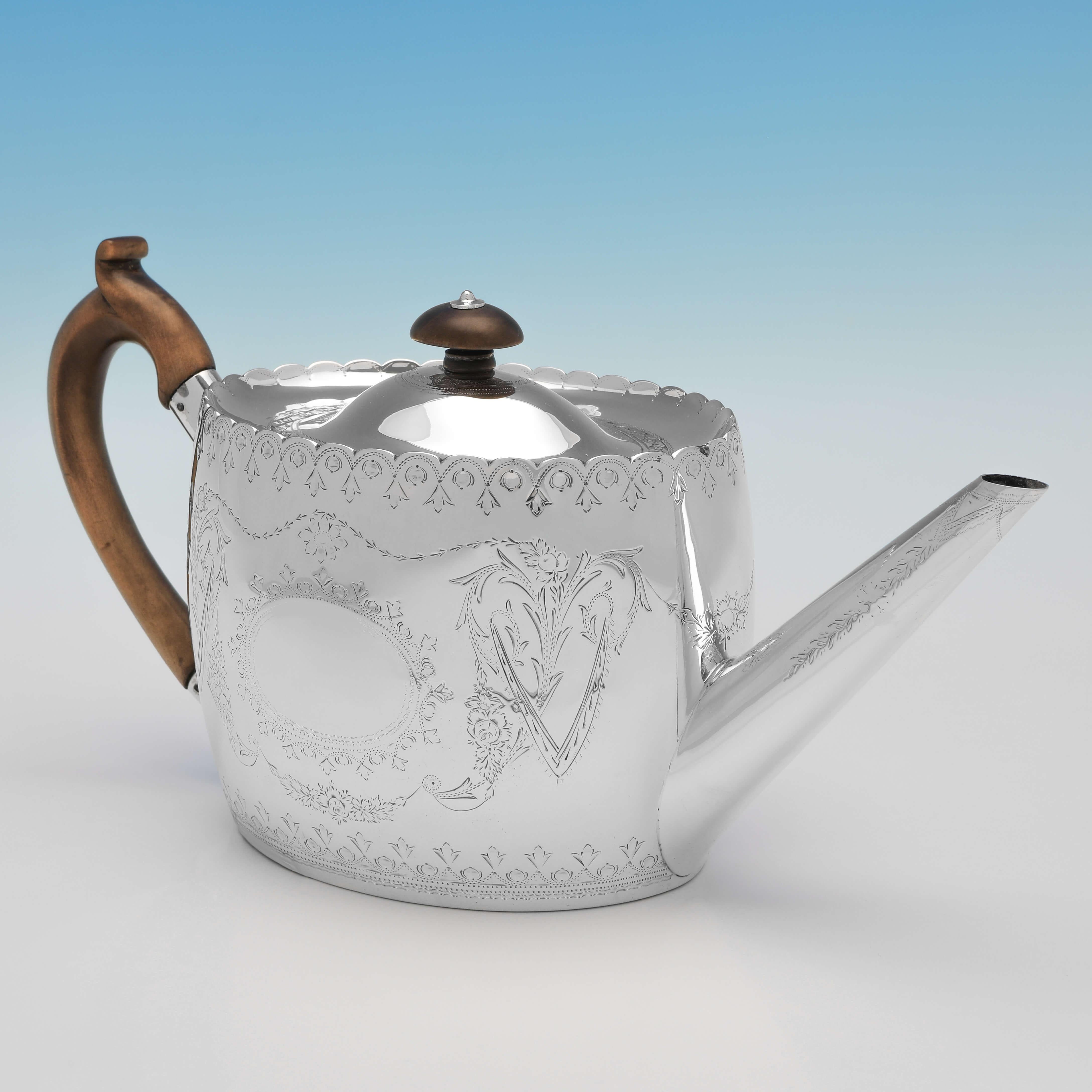 Hallmarked in London in 1881 by Henry William Curry, this attractive, Victorian, Antique sterling silver teapot, features engraved detailing throughout, a wooden handle and finial, and a shaped rim. The teapot measures 5.75