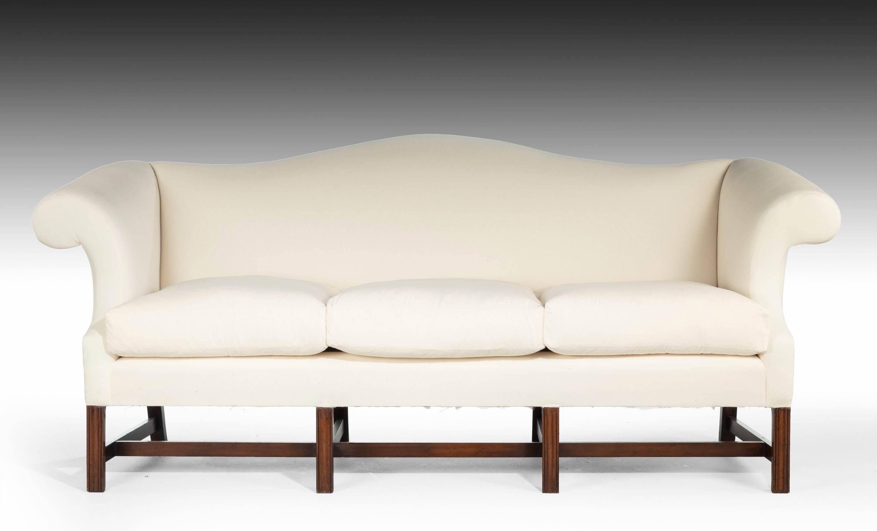 An attractive mahogany framed camelback sofa in the manner of Thomas Chippendale. Totally upholstered in our own workshops now to white.

Measures: Seat height 21.5 inches.