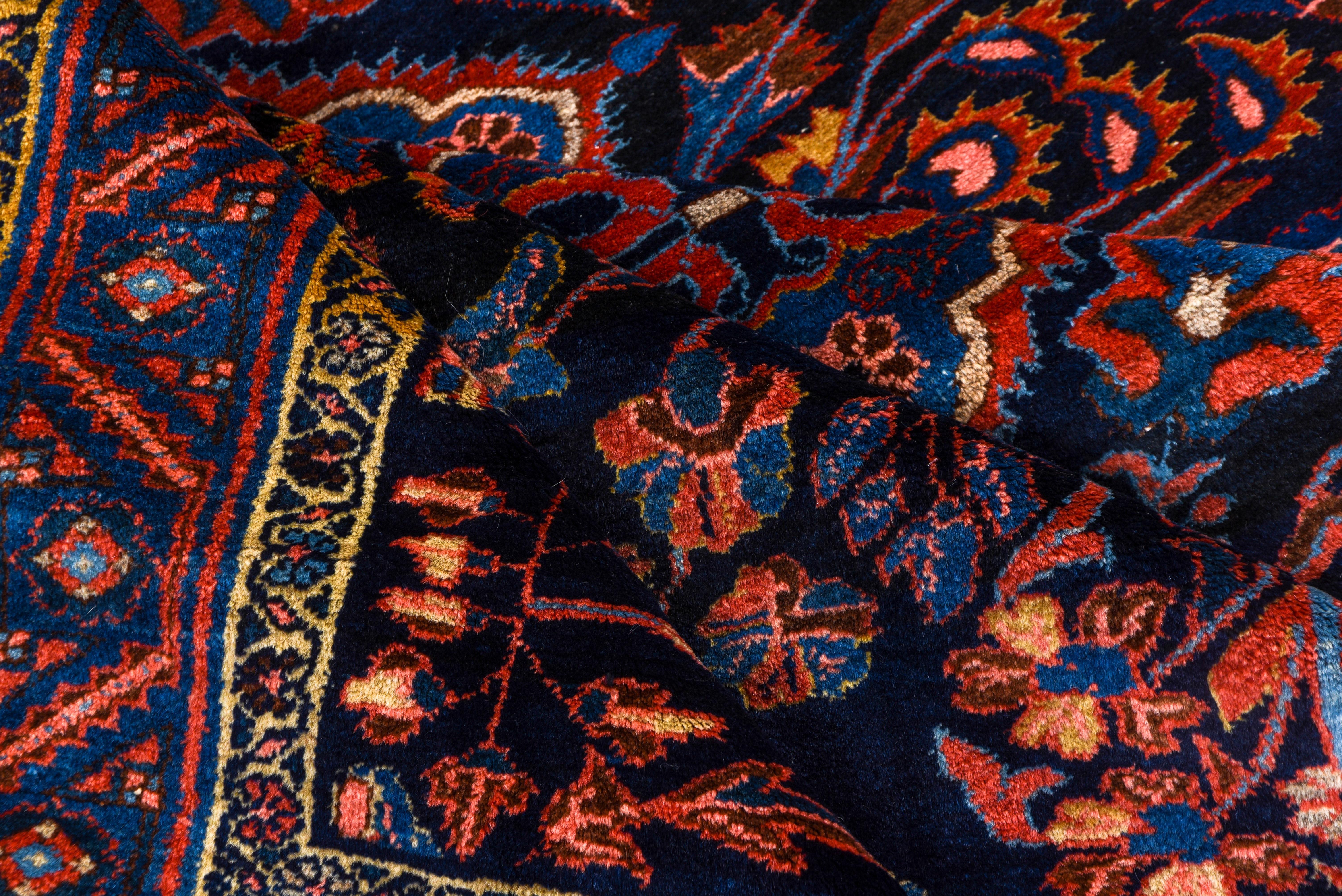 This attractive west Persian village scatter shows a central column of cerulean blue cartouches and floral sprays flanked by colorful vines and flowering spirals. Yellow and rust-orange accents. Crisp blue slanted leaf border. Good condition with