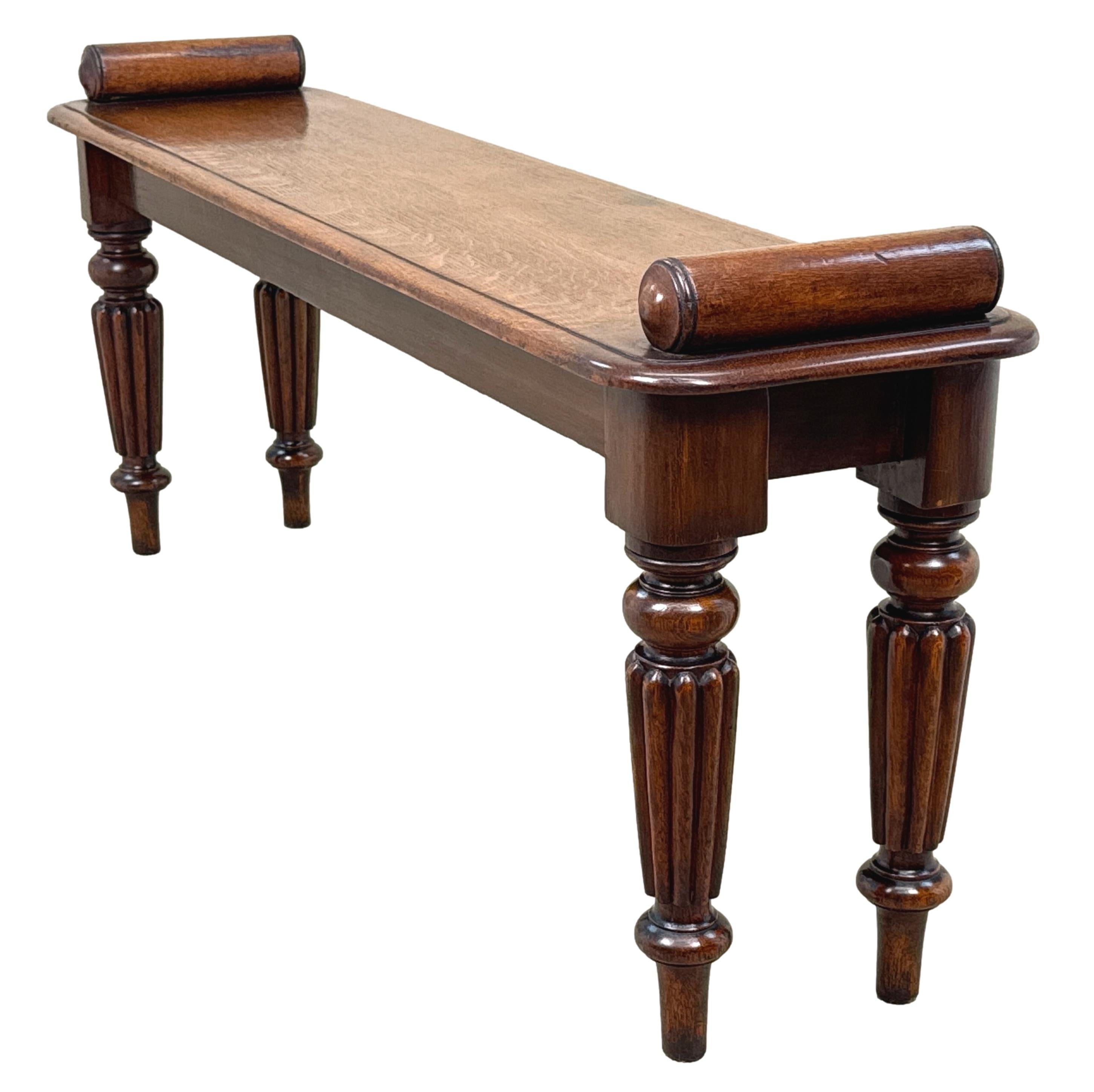 A Very Good Quality 19th Century Late Regency Period Oak Window Seat, Or Hall Bench, Retaining Good Rich Colour Throughout, Having Turned Rolls To Each End Of Rectangular Top, Raised On Elegant Reeded Turned Tapering Legs.

Hall benches from the