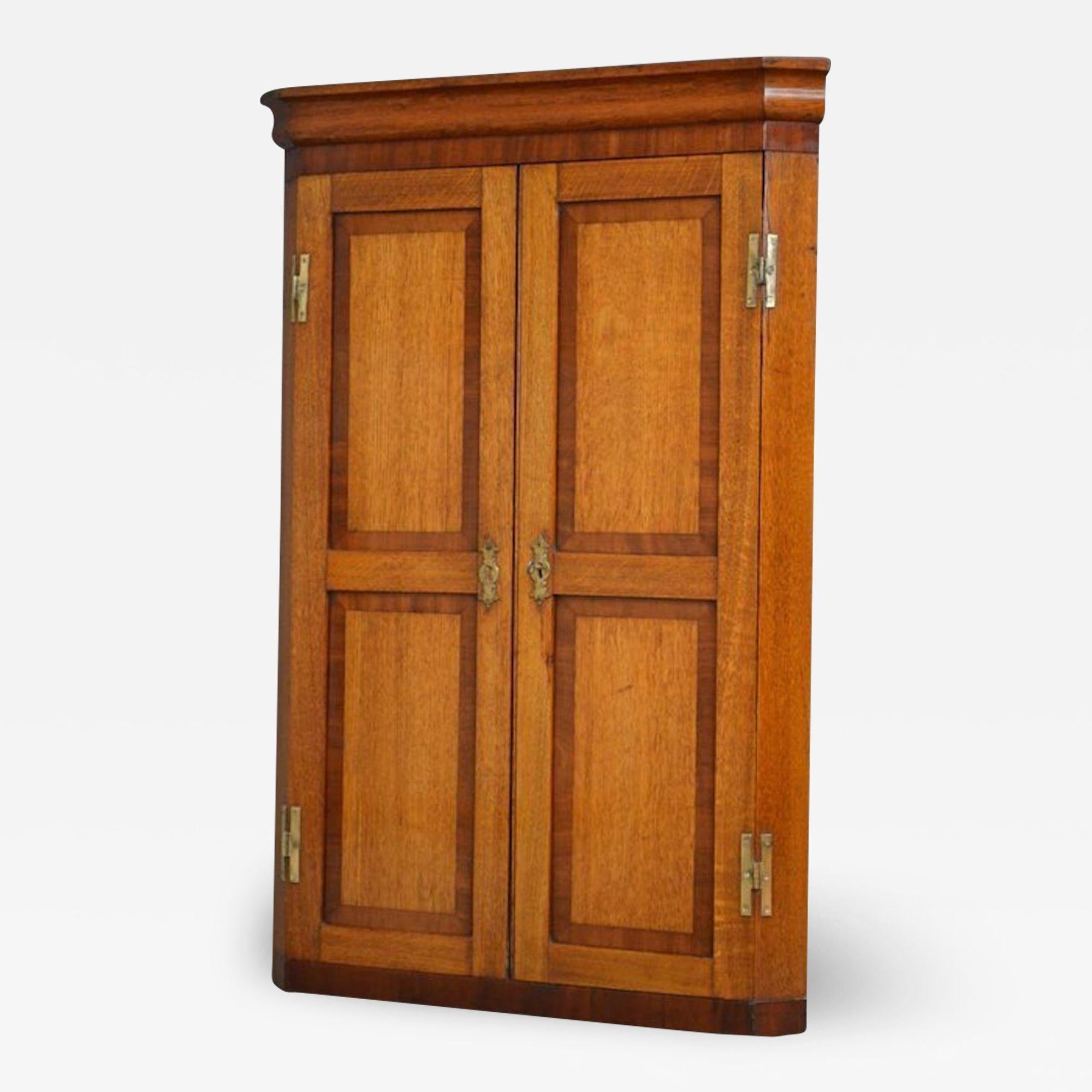Sn3878, an attractive, Victorian oak and mahogany banded corner cupboard of soft and warm colour, having moulded cornice above a pair of double panelled cupboard doors enclosing shaped shelves, all fitted with original H hinges, brass escutcheons
