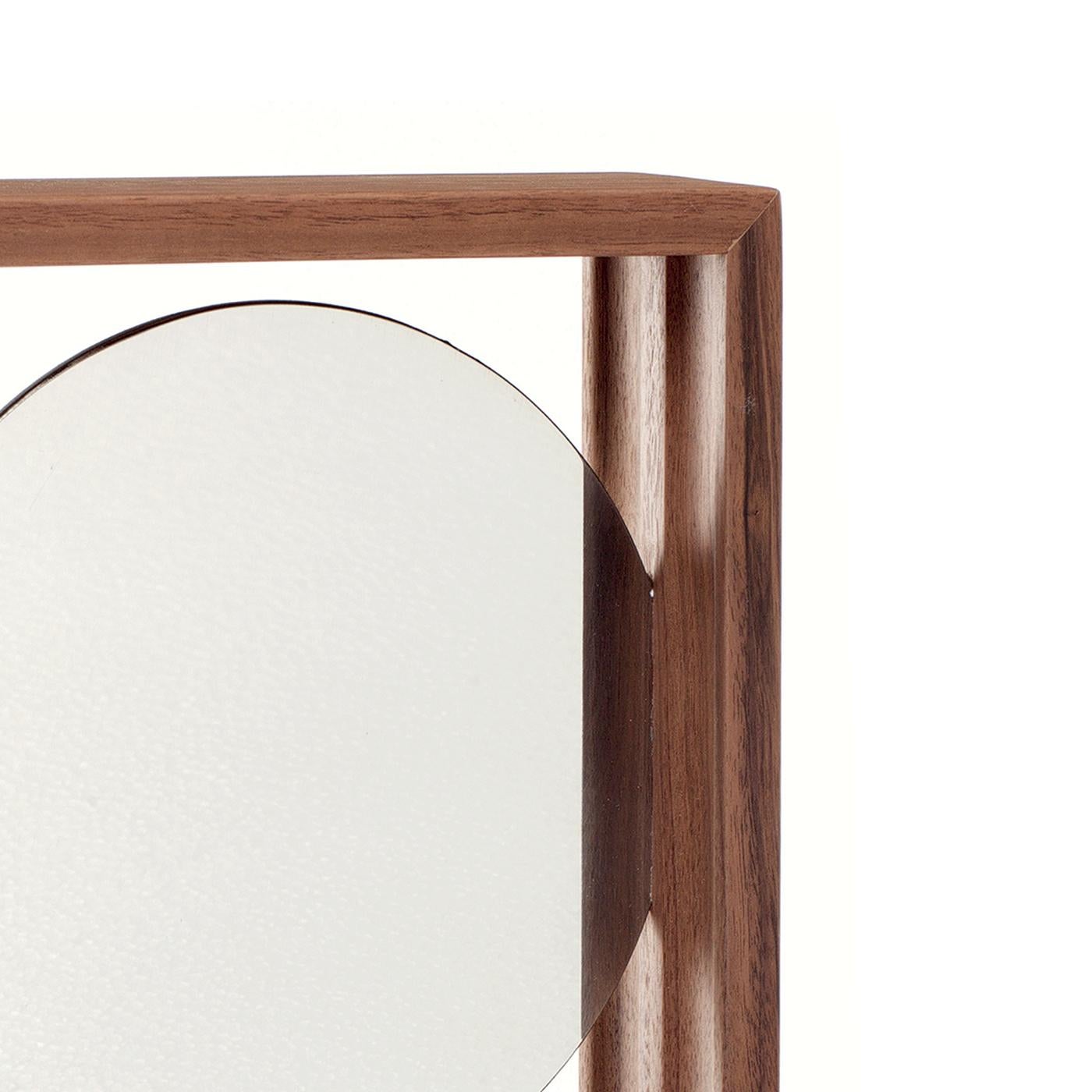 Charming in its simplicity, this round wall mirror by GumDesign will be a sophisticated addition to both traditional and contemporary decors. Enclosed in a superb frame crafted of solid Canaletto walnut with a natural finish, the round mirror partly