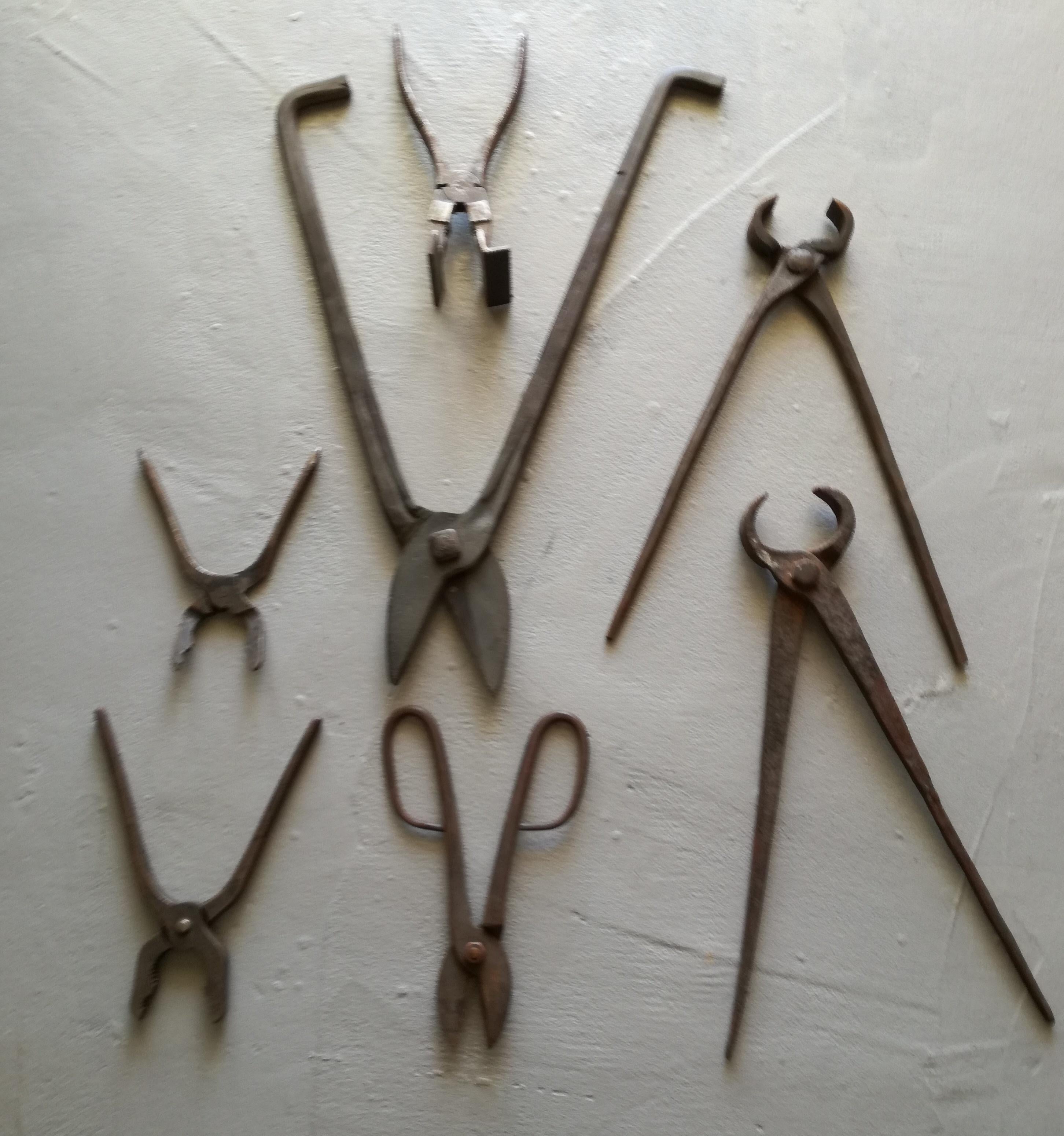 Ensemble de sept outils de forge en métal (cisailles et tenailles) provenant d'un atelier de forgeron, années 1940-1950. Différents types et tailles. Les mesures indiquées se réfèrent à l'outil le plus grand. Bon état : il y a un peu de rouille mais