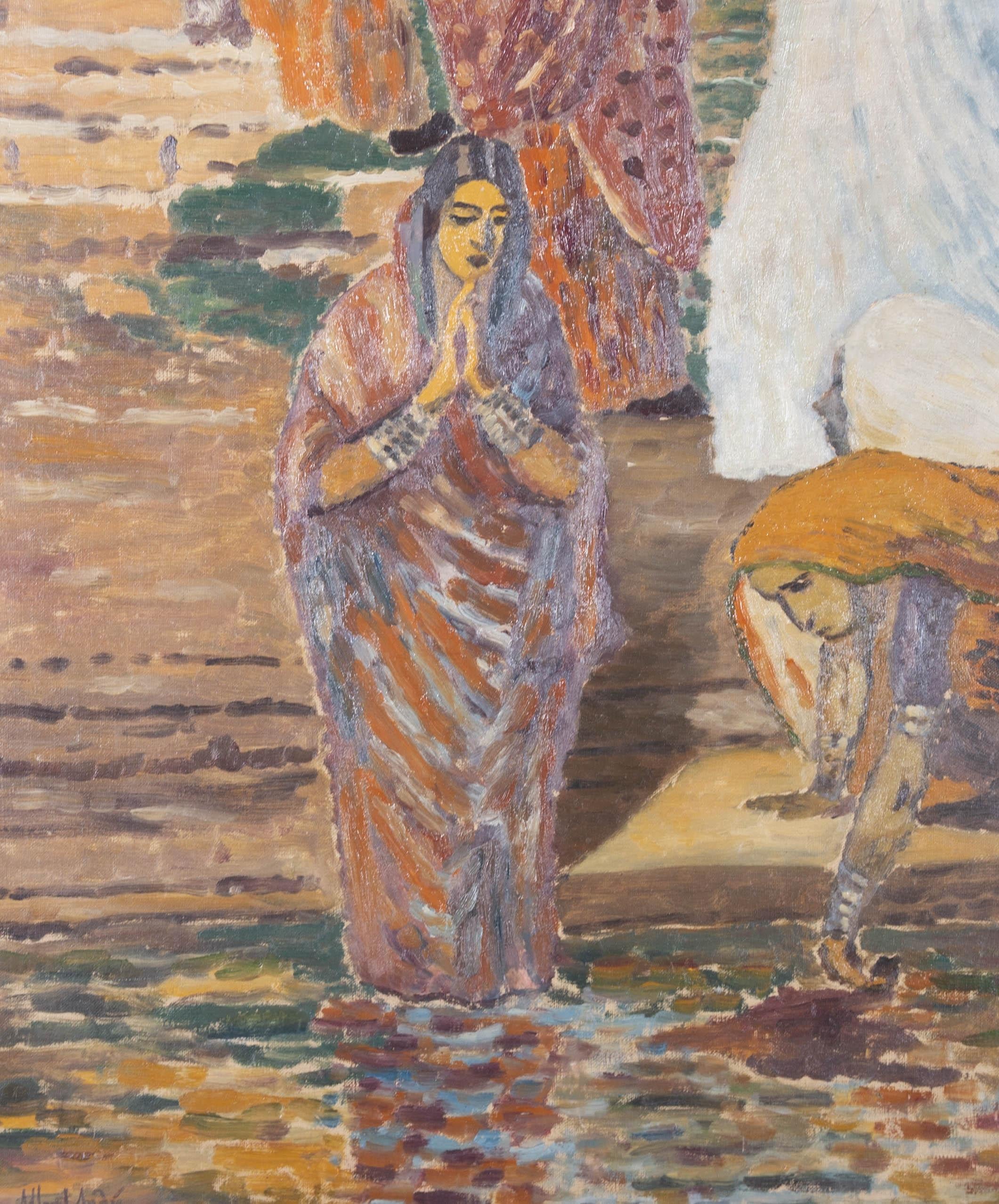 A masterful French Impressionist oil showing a beautiful woman in a sari and metal bracelets, standing and praying at the steps of the Ganges. Another woman can be seen washing cloth in the waters to her right. The artist's use of earthy tones adds