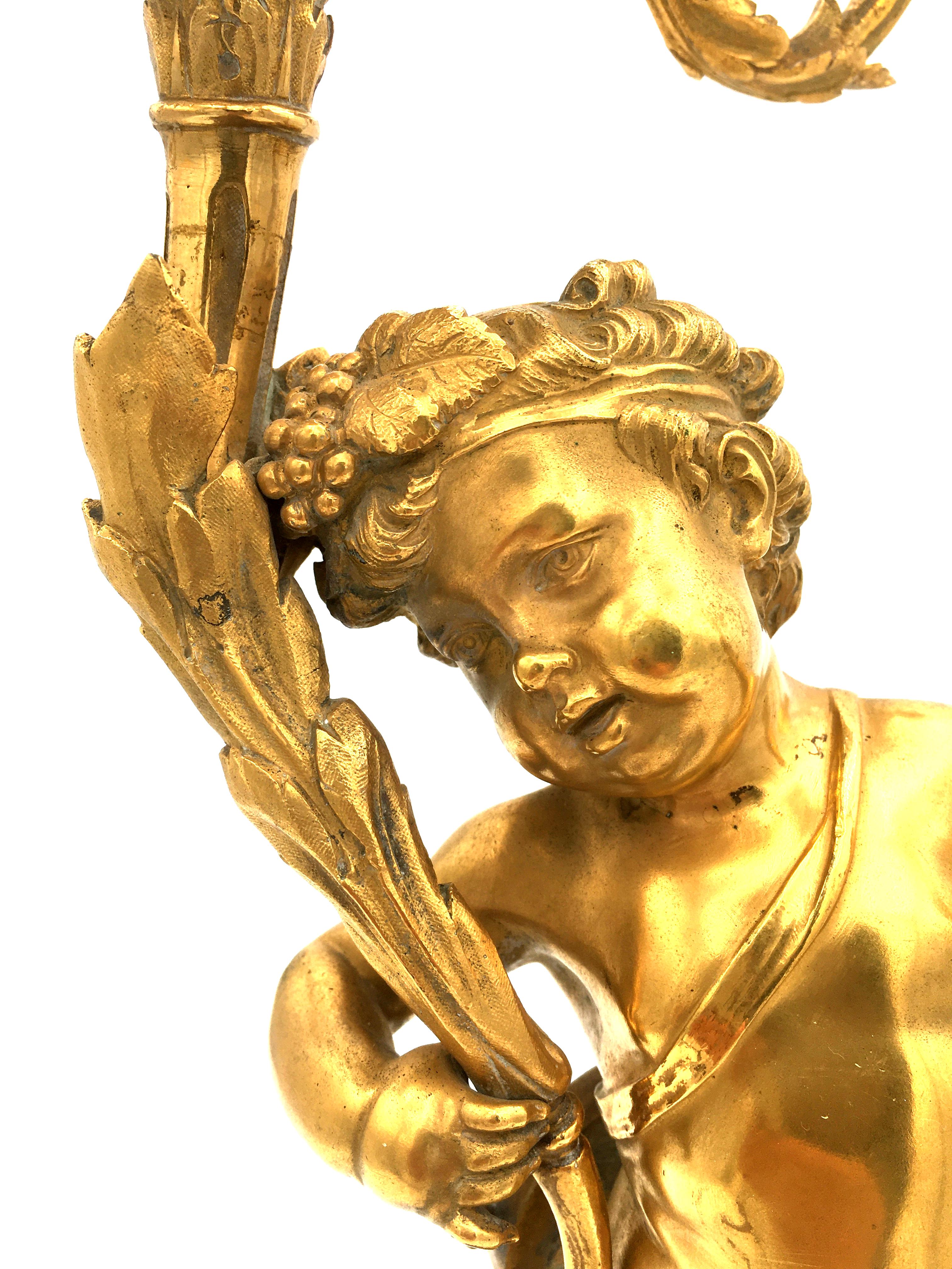 Magnifique paire de candélabres français en bronze doré de grande qualité, datant de la fin du XVIIIe siècle ou du début du XIXe siècle, reposant sur un piédestal circulaire en marbre rouge Griotte et sur des pieds dorés. Chaque candélabre est doté