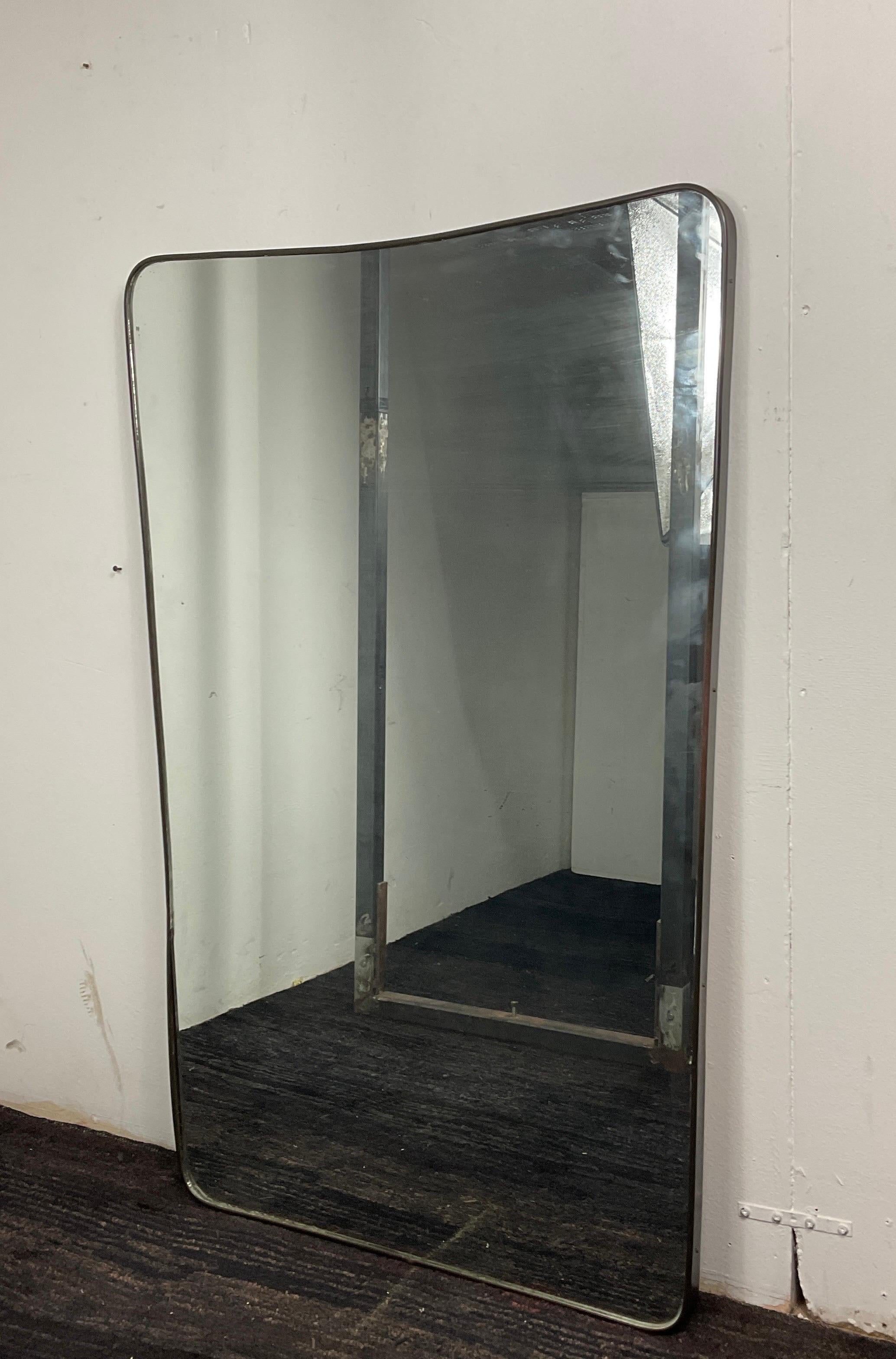 Mirror of the 70s in brass attributable to Gio Ponti. Brass frame with solid wood surface at the back and mirror. In good condition with wear and tear caused by years and use. Please view the pictures carefully. Architect, designer and academic, Gio
