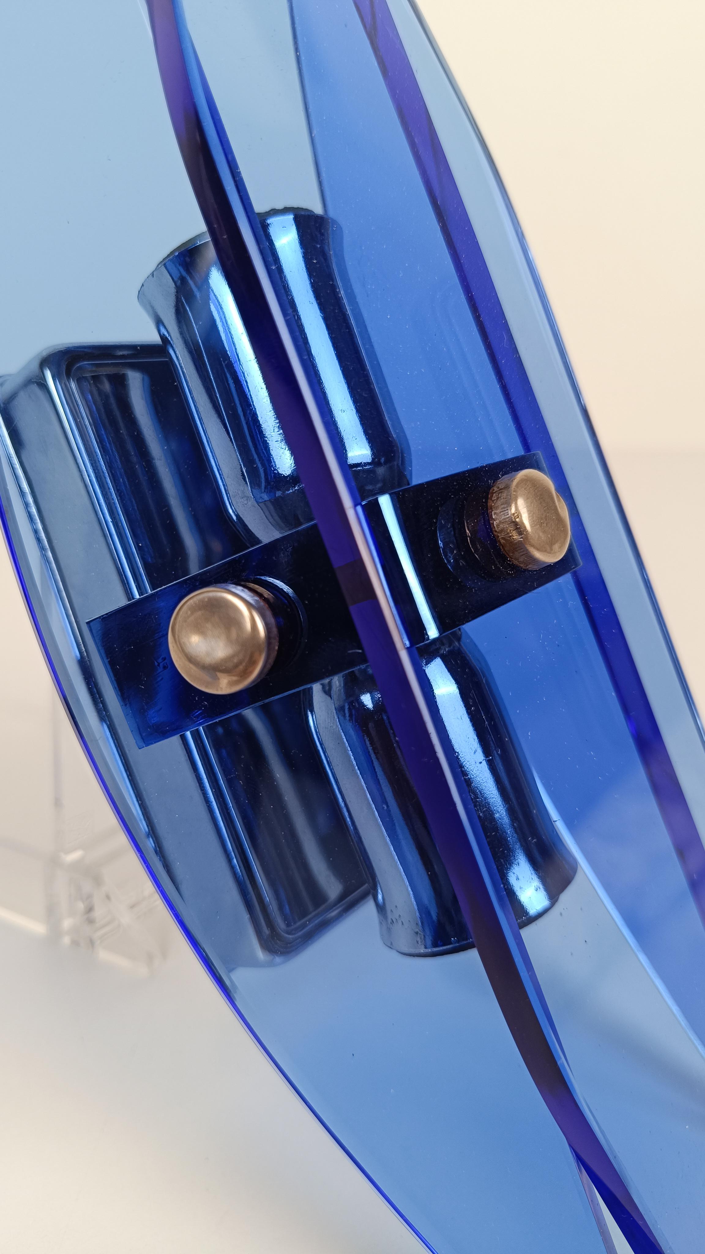 Nous proposons à la vente une belle paire d'appliques murales à lames de verre bleu stylisées d'après Fontana Arte.
Fabriquée en Italie entre les années 60 et 70, chacune de ces appliques vintage est composée de 3 feuilles de verre bleu outremer