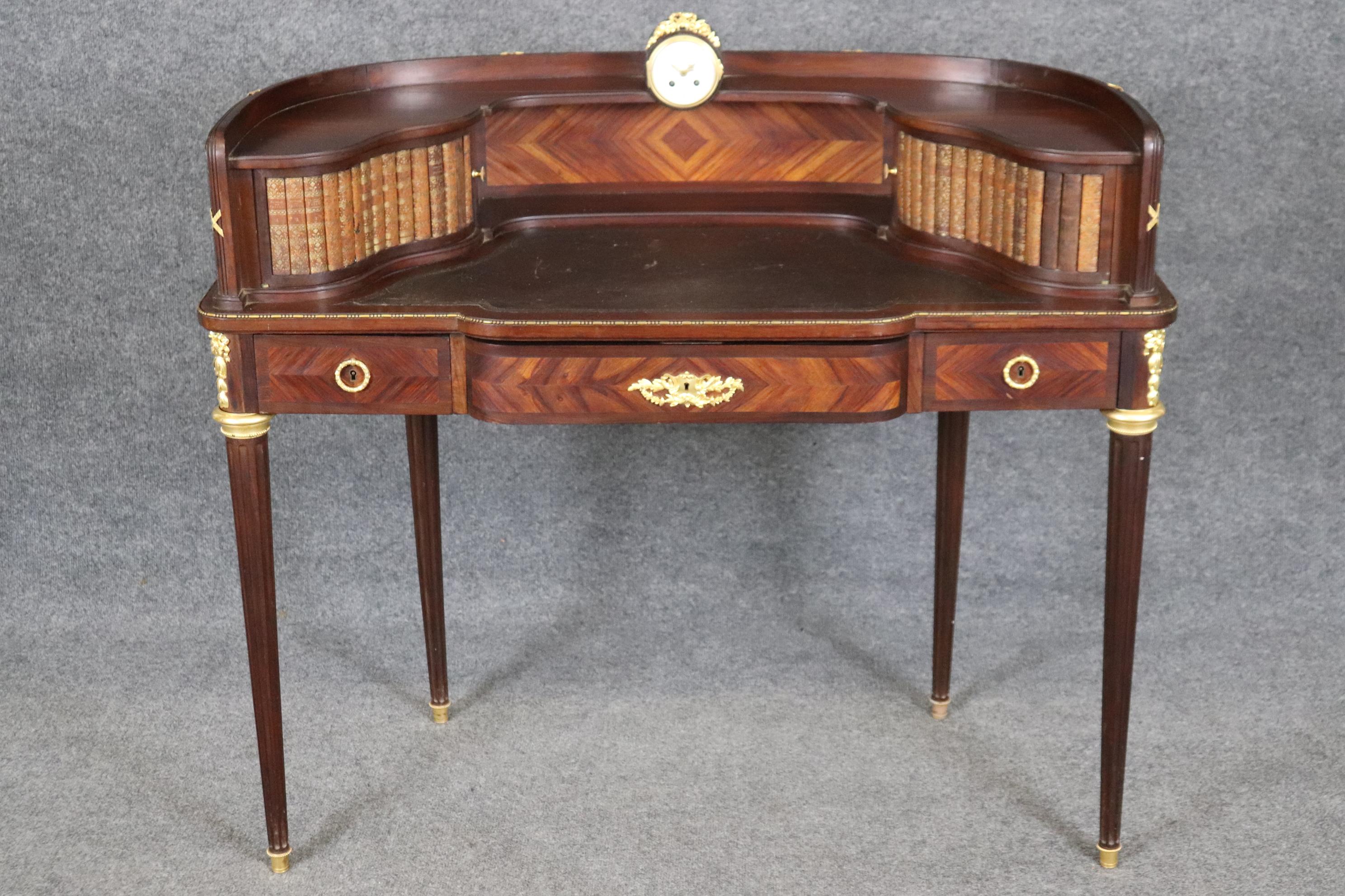 This is a superb, beautifully designed writing desk with a clock and faux book spines atop a leather writing surface. The desk is attributed to Francois Linke of Paris and has some of the finest gold Dore' bronze ever. Read the attached information