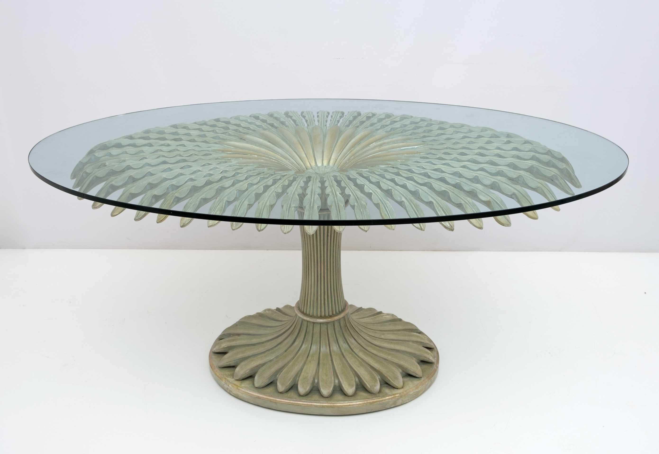 Spectacular dining or center table in finely carved ivory lacquered gilded wood of Italian design with oval crystal top. Attributed to Pier Luigi Colli.
