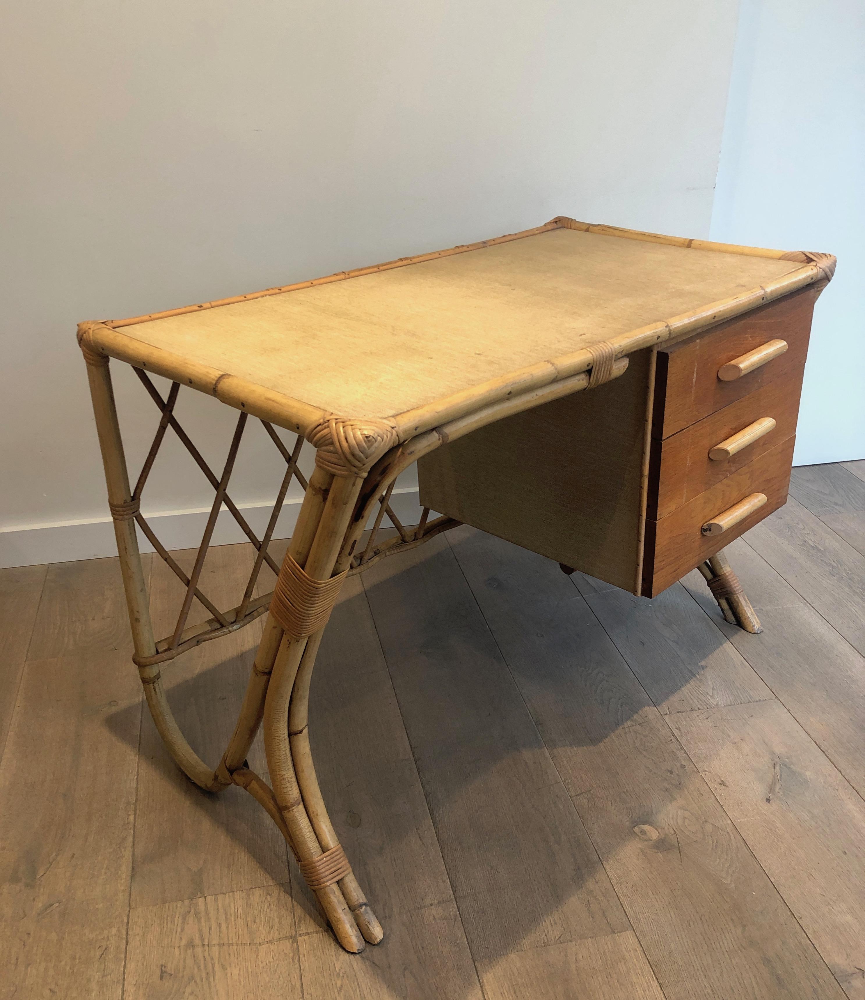 This nice design desk is made of wood and rattan. This is a nice work attributed to famous French designer Audoux Minet, circa 1970.