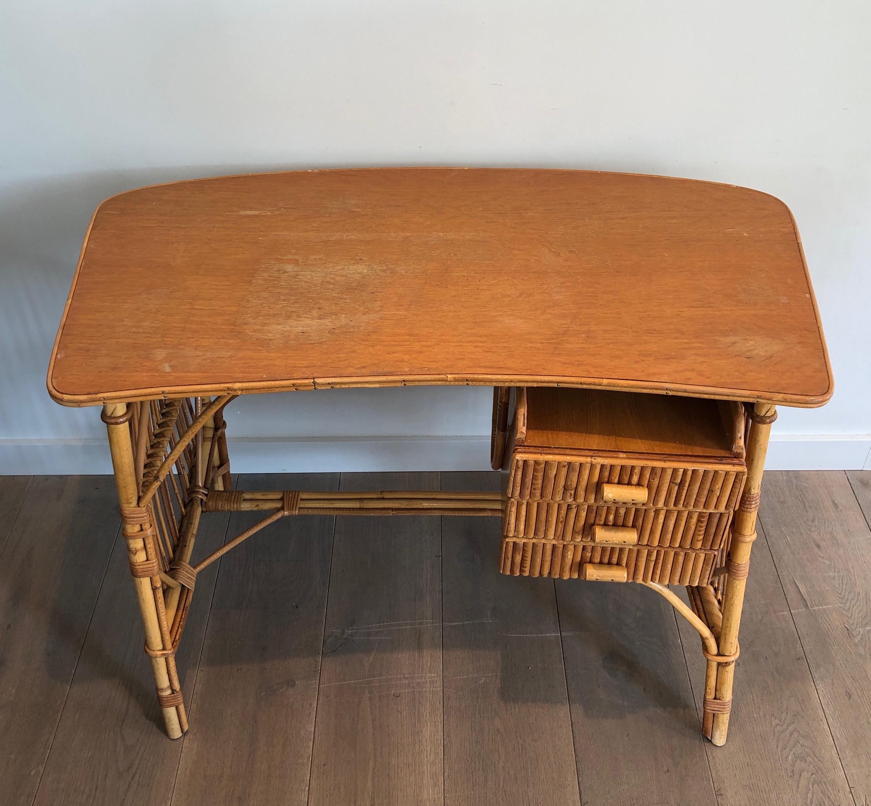 Dieser ungewöhnliche Schreibtisch mit Schubladen ist aus Bambus, Holz und Rattan gefertigt. Es handelt sich um ein Werk, das dem berühmten französischen Hersteller Audoux Minet zugeschrieben wird, um 1970.