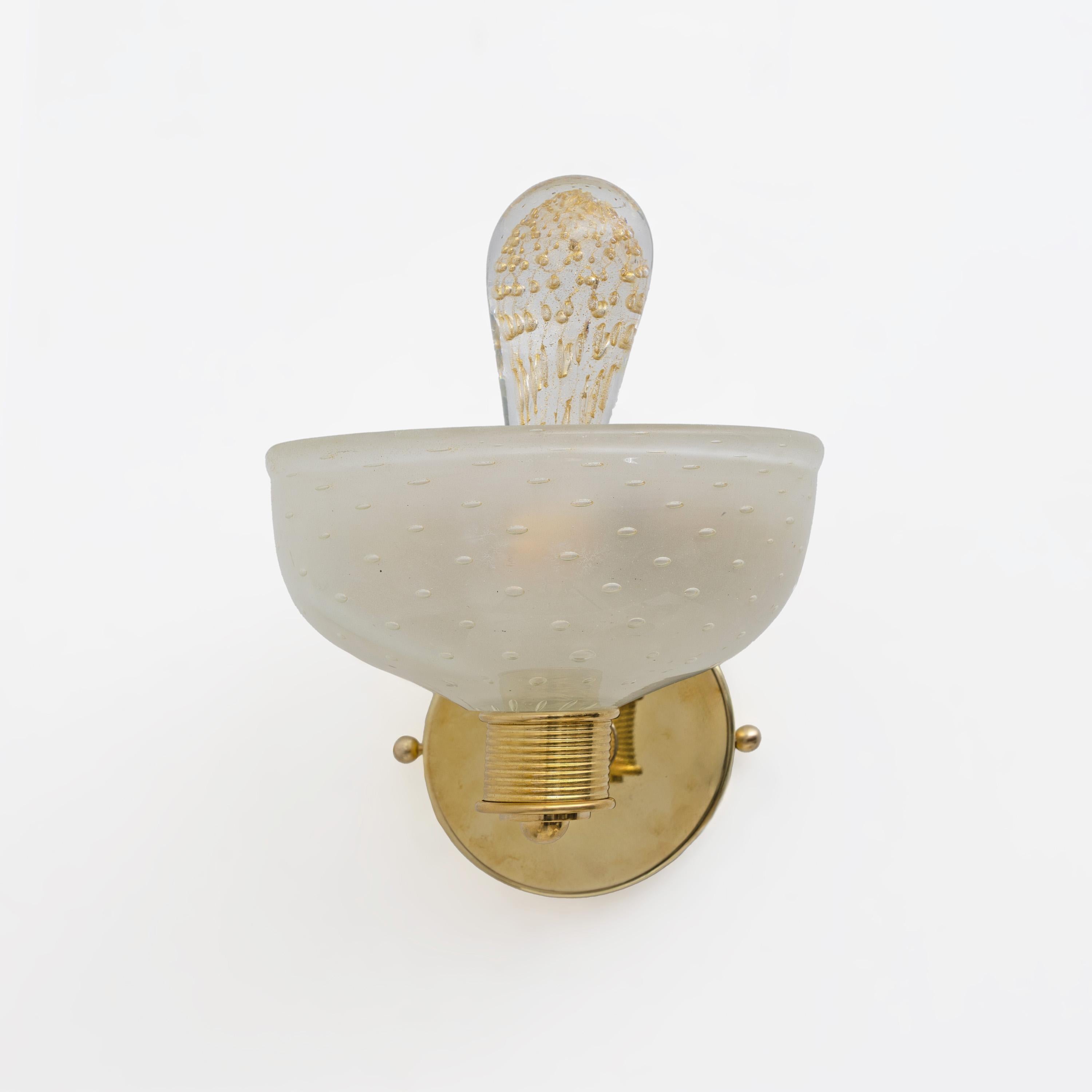 This fabulous pair of Art Deco Murano glass wall lamps is entirely handcrafted. They are decorated using the Pulegoso technique, which features large air bubbles within the high-quality blown glass, created with inclusions of 24-karat gold dust.