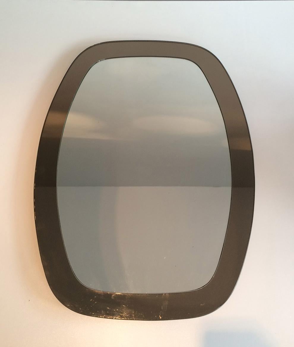 Ce miroir est composé de miroirs bicolores, un miroir classique entouré d'un miroir fumé. Il s'agit d'une œuvre attribuée par la célèbre firme italienne Fontana Arte, vers 1970.