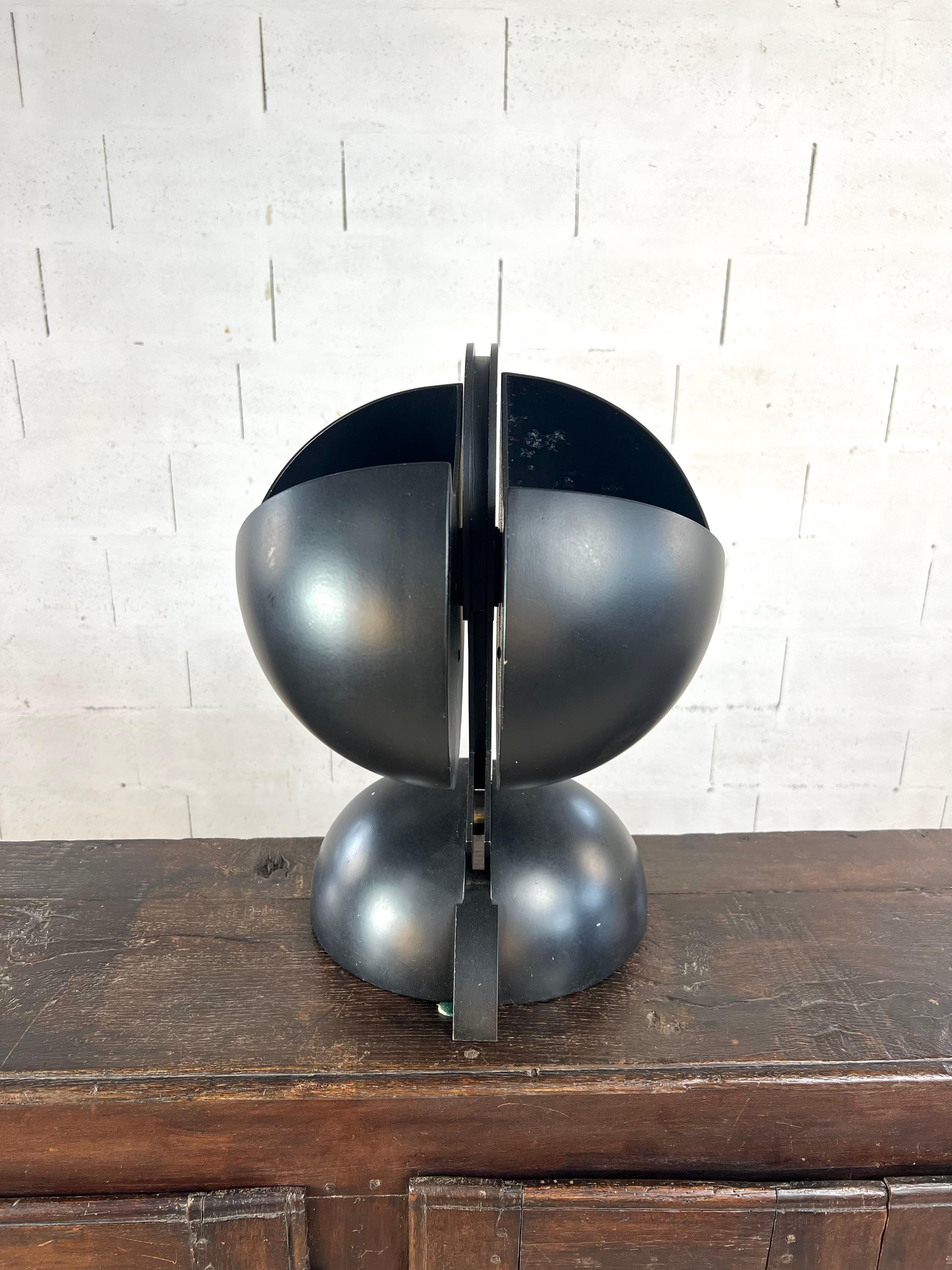 A rare and highly sculptural Italian table lamp in matte black lacquered metal, stylistically attributed to renowned designer Gae Aulenti. This 1970s piece evokes the experimental language of the Space Age, with a refined architectural