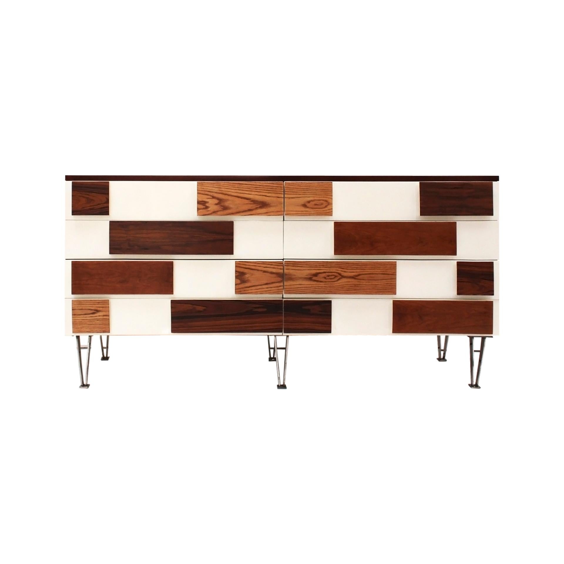 Splendida credenza italiana degli anni '50 con otto cassetti realizzata in noce e rifinita con un'elegante lacca bianca. I cassetti sono impreziositi da maniglie uniche realizzate con diversi tipi di legno, tra cui rovere, frassino, noce e olmo, che