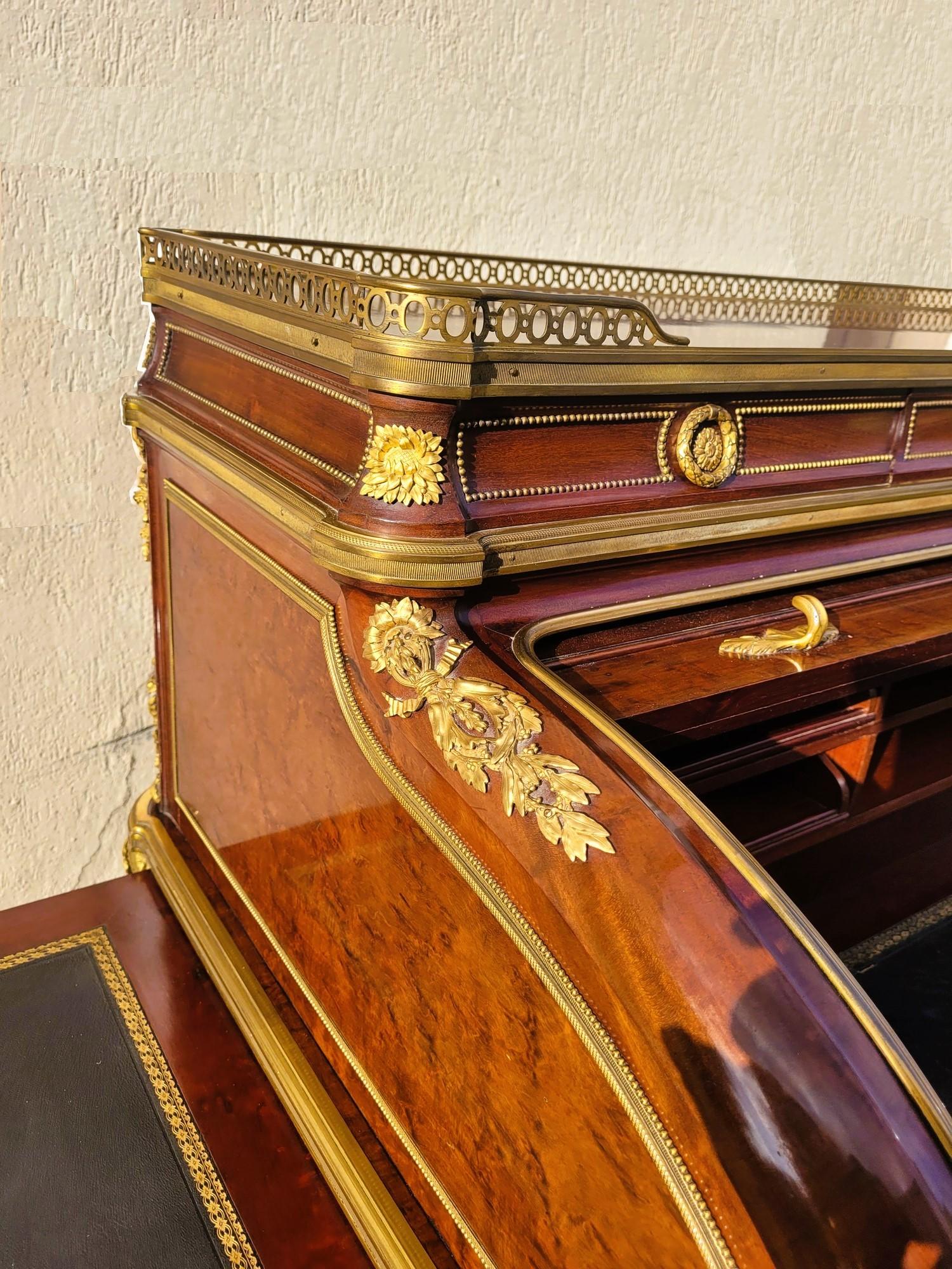 Bellissima scrivania a cilindro in legno impiallacciato, su un'anima in Oak, con ricchi ornamenti in bronzo cesellato e dorato: fiori, foglie d'acanto, zampe di leone...
Si apre sul davanti grazie a un sistema di lamelle scorrevoli (cilindro) su una