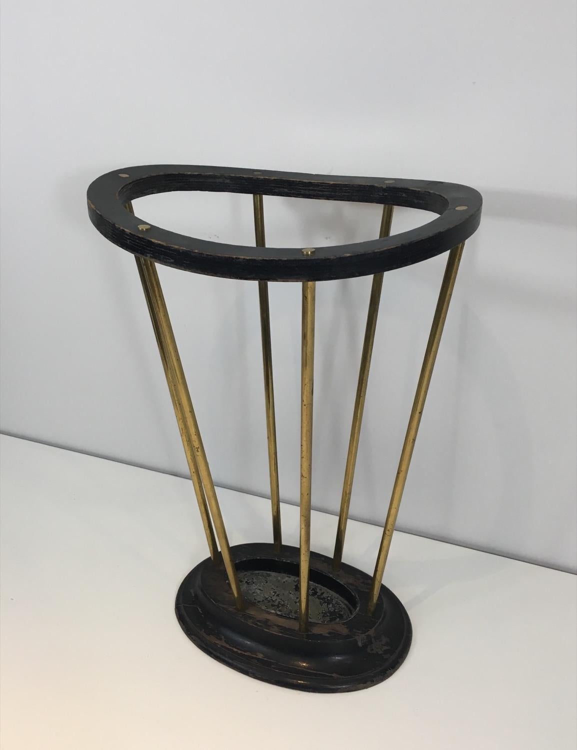This very nice and rare umbrella stand is made of ebonized wood and brass. This is a French work. Circa 1950.