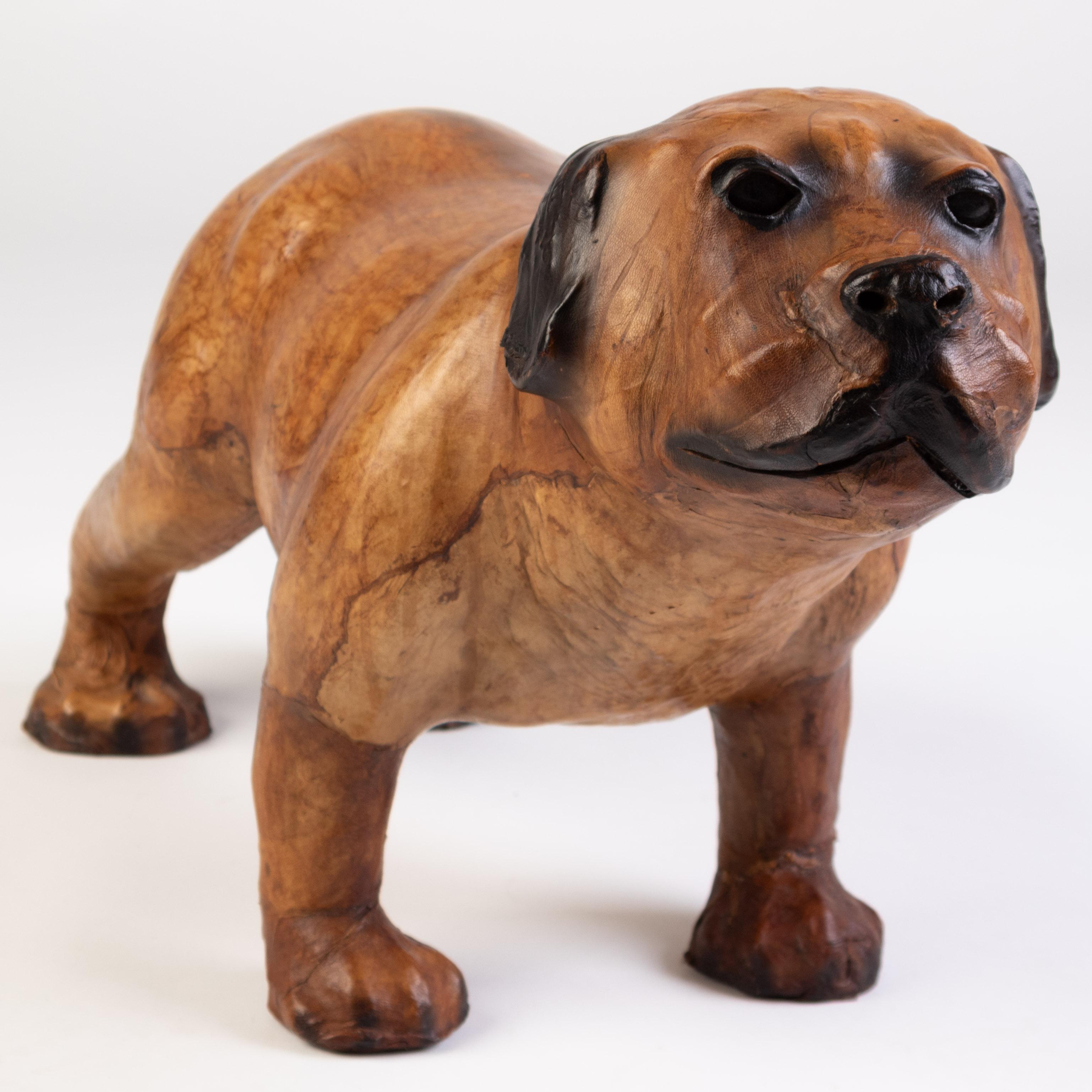Questo eccezionale poggiapiedi in pelle per cani di campagna dell'inizio del XX secolo è attribuito a Liberty & Co., rinomata per i suoi iconici design ispirati alle arti e ai mestieri. Caratterizzato da un affascinante e realistico motivo di cani,