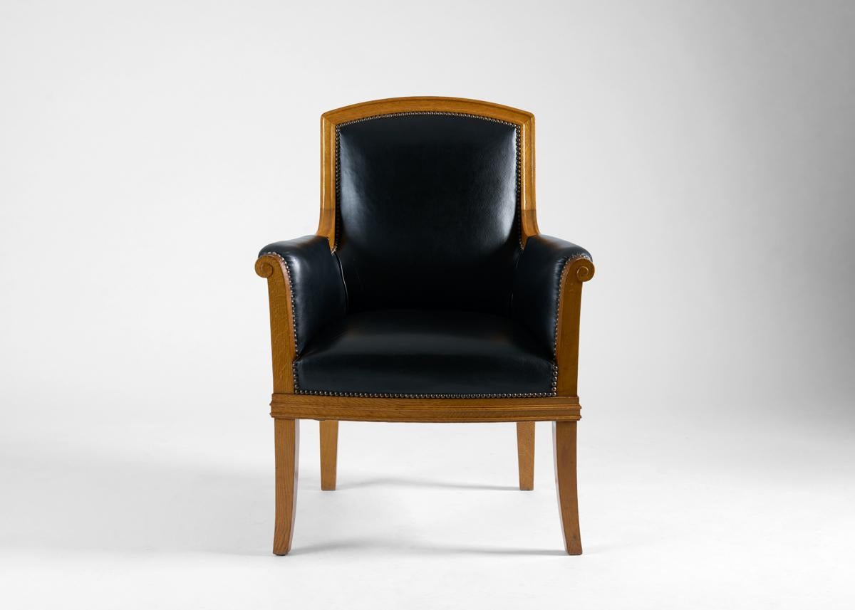 Questa poltrona vanta gambe delicatamente distanziate e braccioli che si arrotolano dolcemente, oltre a un elemento del tutto distintivo: un elemento nei rivetti in acciaio che adornano i punti in cui il rivestimento in pelle incontra la struttura