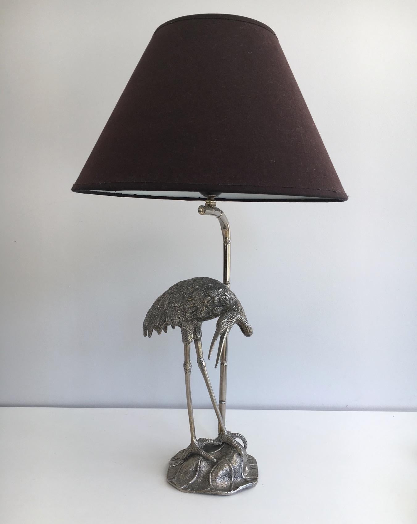 This unusual silvered lamp is showing a heron standing near a bamboo. It is very decorative. It is a French work, attributed to the famous French house Maison Bagués, circa 1960.