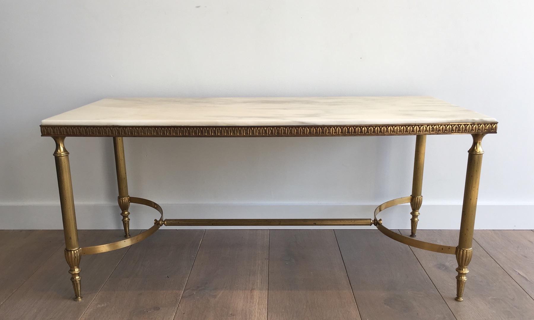 Cette table basse néoclassique est fabriquée en laiton avec un plateau en marbre blanc. Cette table de cocktail est attribuée à la célèbre maison française Jansen:: vers 1940