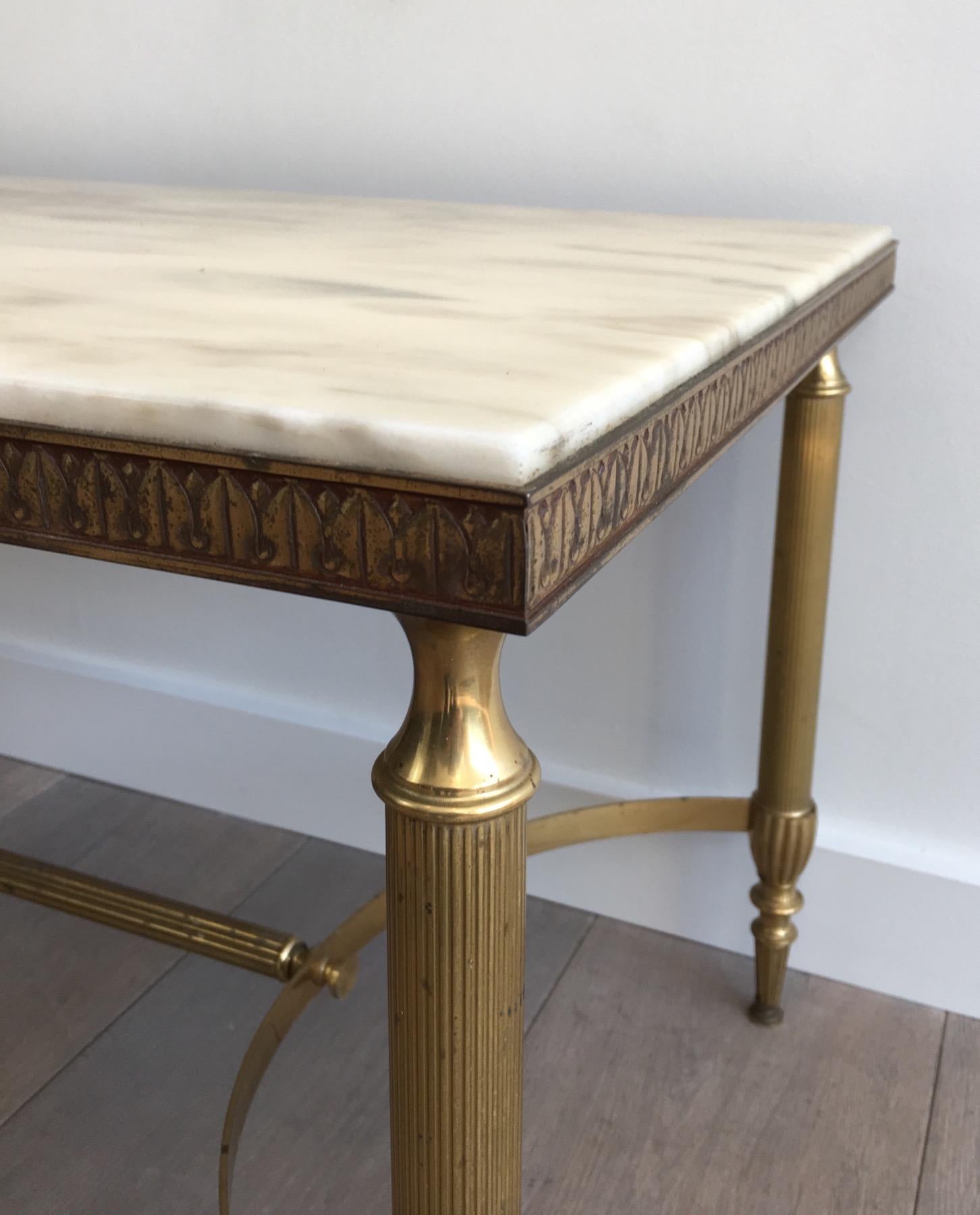 Milieu du XXe siècle Attribué à la Maison Jansen. Table basse néoclassique en laiton avec plateau en marbre
