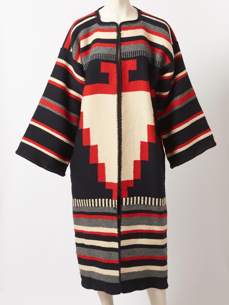 Michaele Voilbracht, graphic pattern, wool coat in red, black and ivory, made from a vintage Navajo Indian Blanket. Wide sleeves are are set off the shoulder having no button closures. The coat is edged in a black wool blanket stitch. Label is
