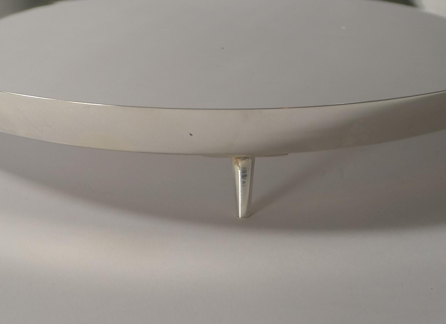 A stunning silver plated circular cocktail tray, futuristic in style with a modernist look, a simple circular galleried shape standing on three pin legs.

Fully marked on the underside for the highly collectable silversmith, Hukin and Heath and the