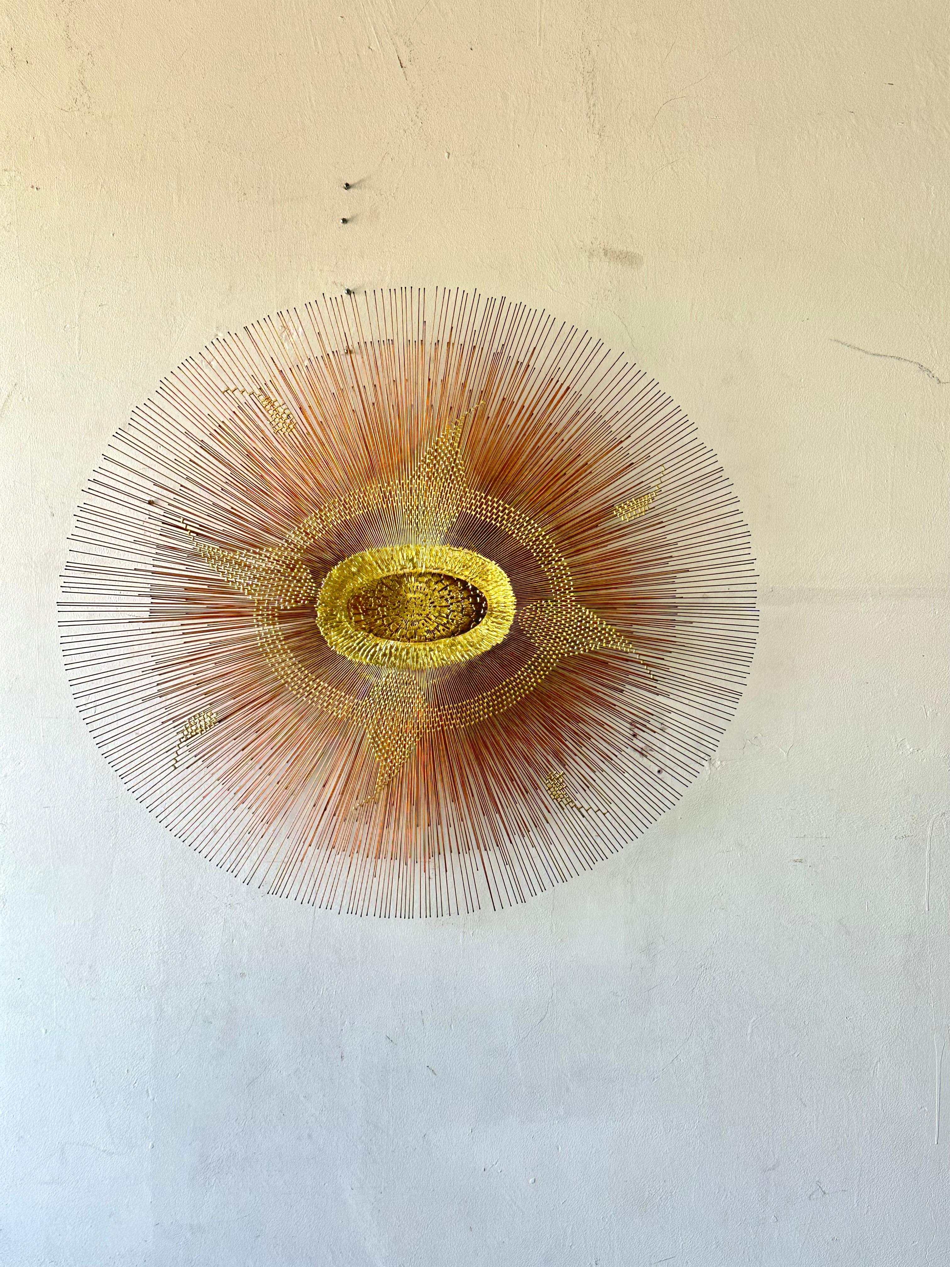 Spectacular Mid-Century Modern large scale sunburst sculpture, circa 1970s. This statement piece is made of metal with 3 different colors: copper, bronze and gold.featuring double layer rods in different lengths. A dramatic focal point to any space