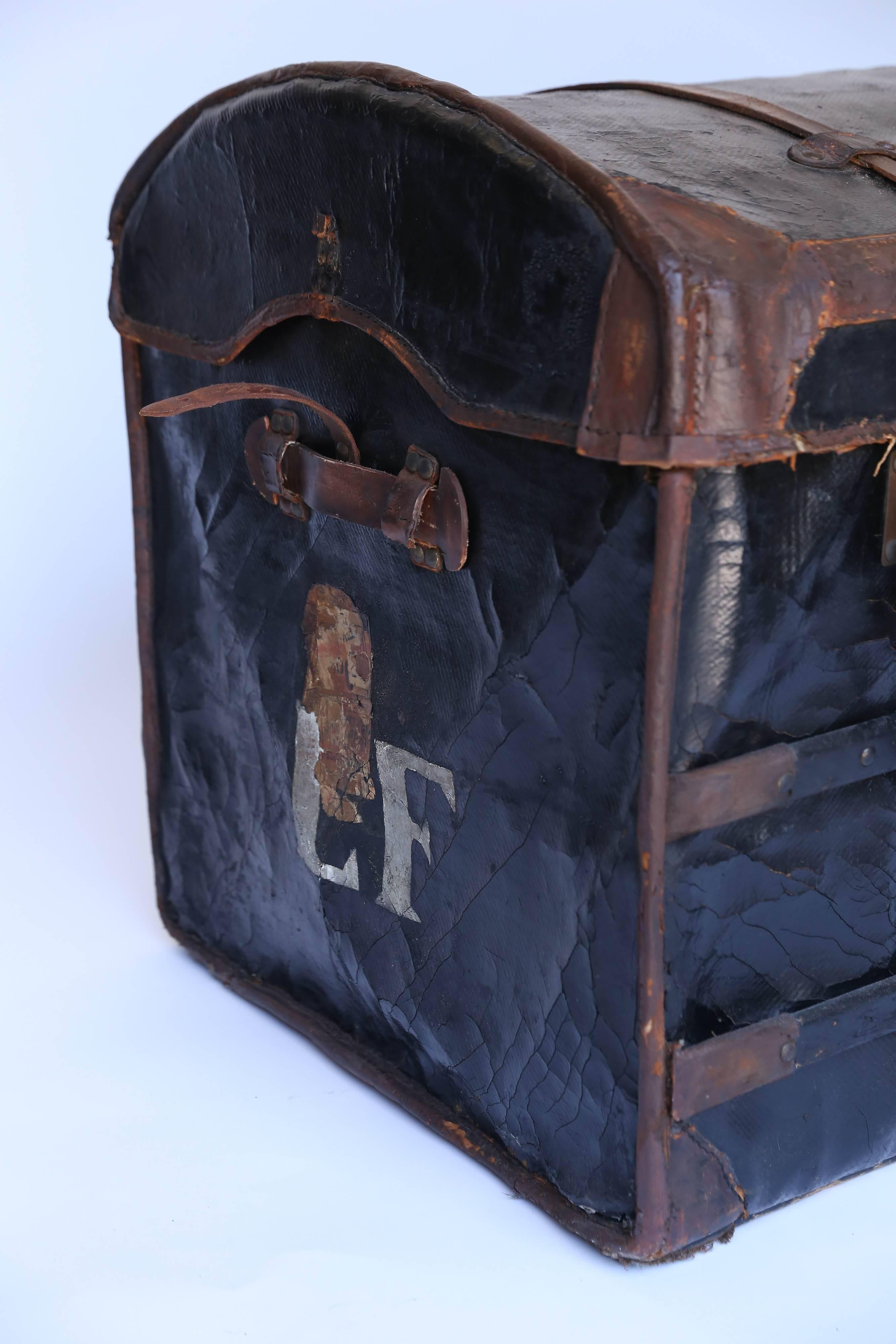 Founded in 1834, Au Depart is considered one of the four greatest French trunk makers. This handsome camel back trunk is superbly constructed of black vulcanized fabric on a woven frame with wood bracings, leather closures and handles attached with