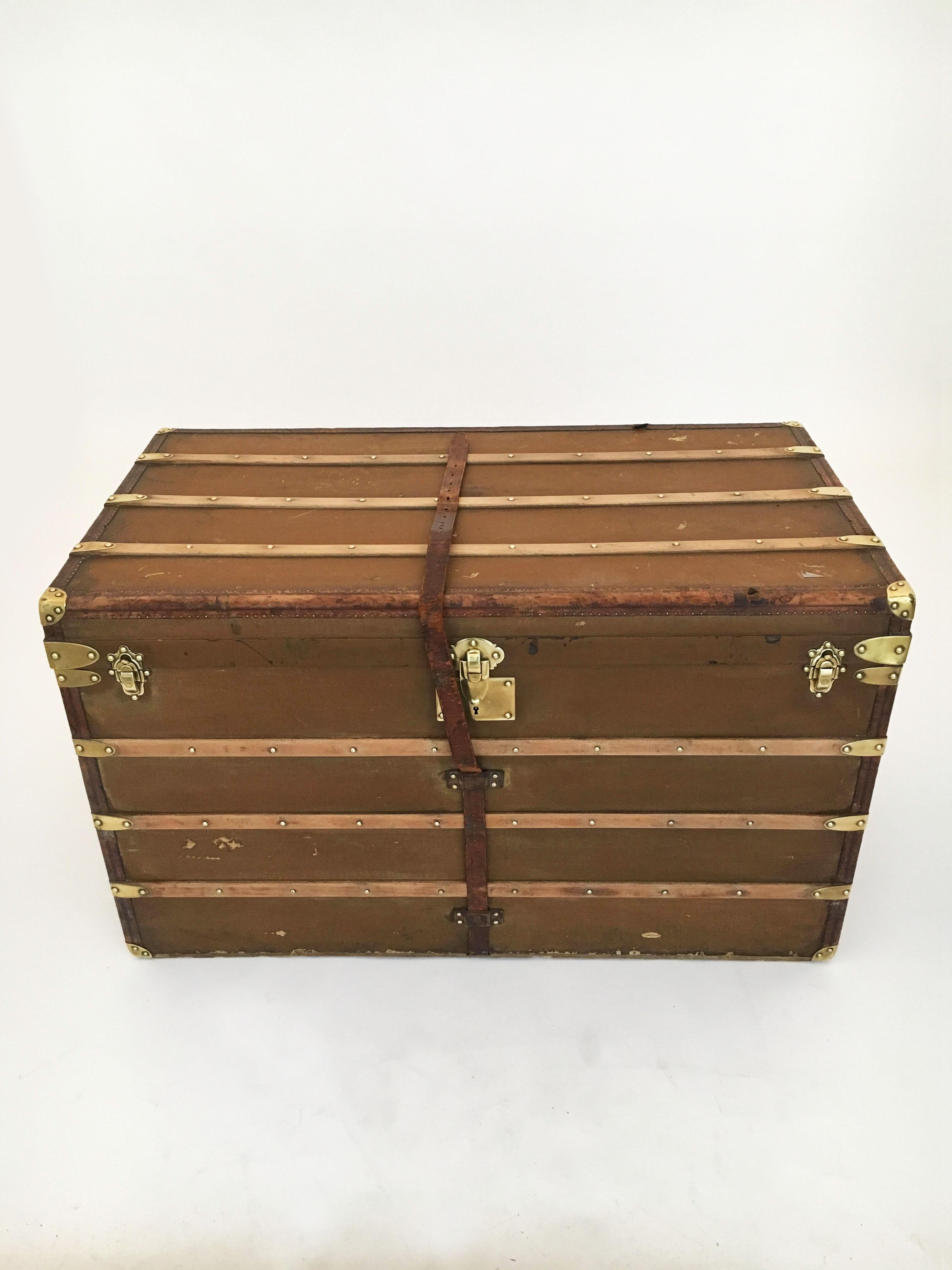 A large Au Départ courier trunk early 20th century, France 1910s. Made of tan vulcanized canvas on a beech wood frame, with exposed wood bracings, leather closures and handles attached with brass rivets - all original displaying the best of classic